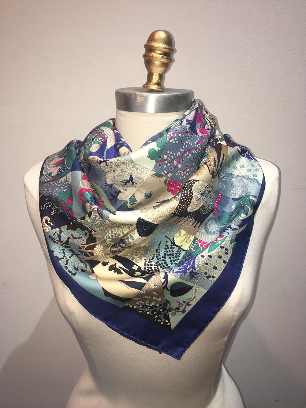 Hermes Tout En Quilt Silk Scarf in Navy in very good condition. Original silk screen design c2008 by Cathy Latham features a patchwork quilt print comprised of small squares depicting foliage, flowers, and vegetation in navy, teal, greens, dark