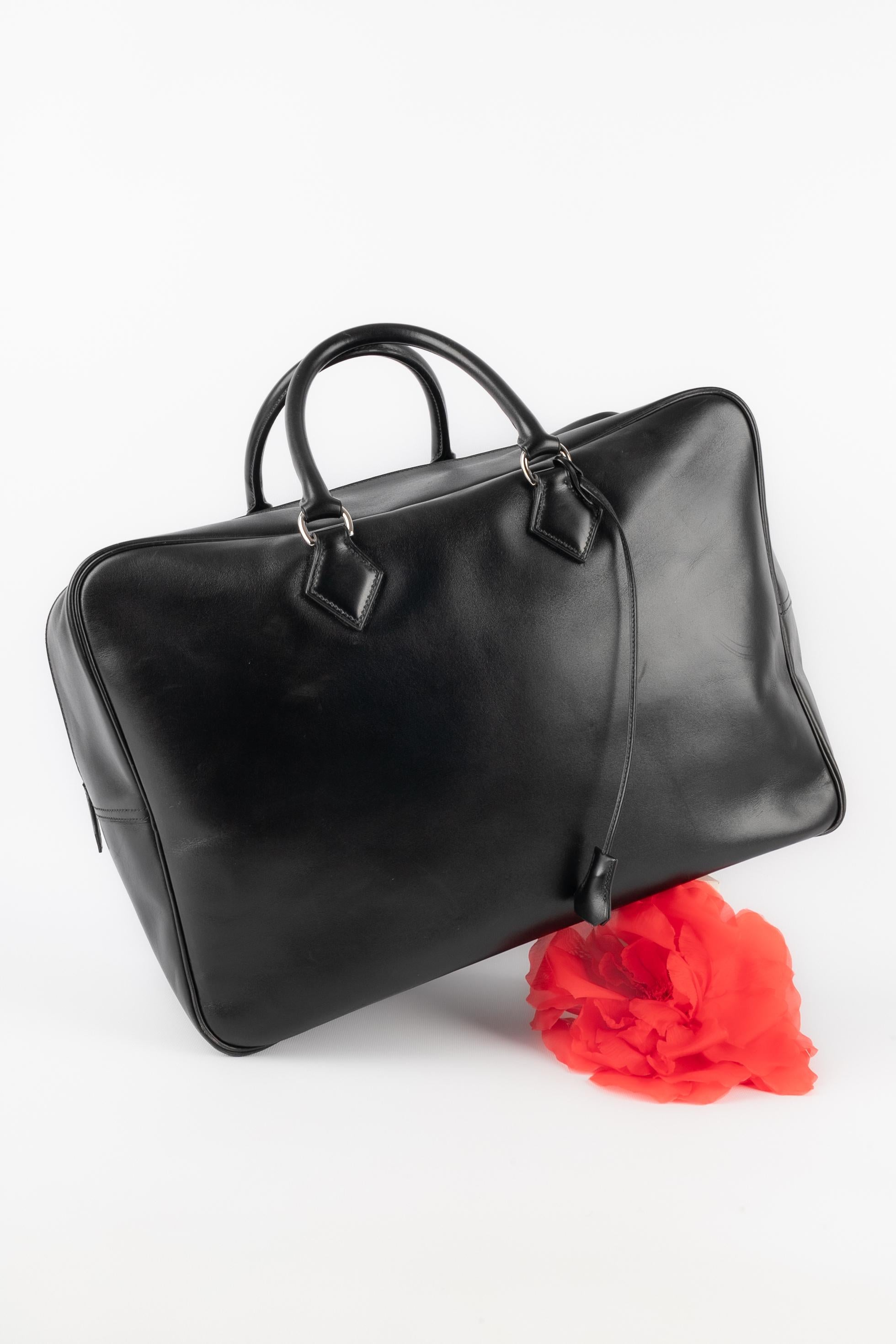 
HERMÈS - (Fabriqué en France) Sac 'plume de voyage' en cuir box noir. Fermeture à glissière et double poignée. Clés sous une minuscule cloche. Collection 2022.

Condit :
Très bon état.

Dimensions :
Hauteur : 31 cm - Largeur : 45 cm - Profondeur :