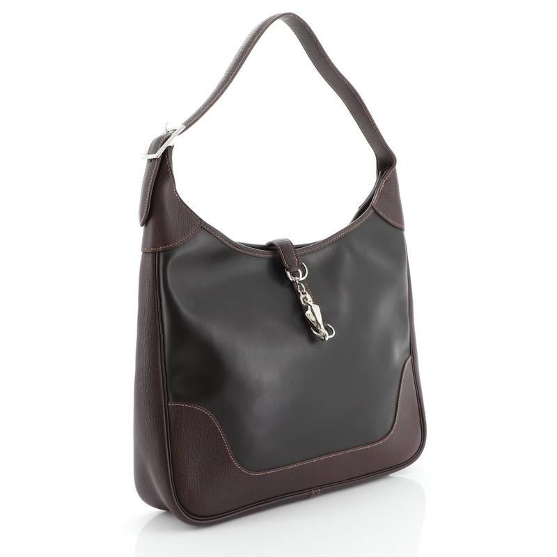 This Hermes Trim II Bag Amazonia Coated Canvas 35, crafted in Havane brown Buffalo Skipper and Amazonia, features a flat silhouette, looped shoulder strap and palladium hardware. It opens to an Ecru brown Toile Chevron interior with side zip and