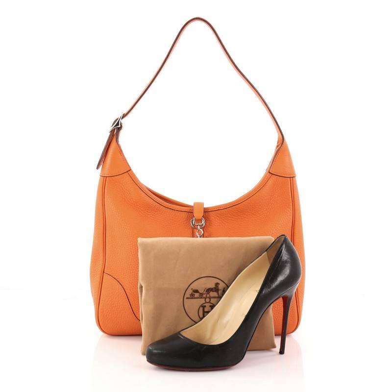 This authentic Hermes Trim II Handbag Clemence 31 is a luxurious and stylish shoulder bag. Crafted in orange clemence leather, this iconic, discontinued bag, features a flat silhouette, looped shoulder strap and a top flap polished hardware closure.