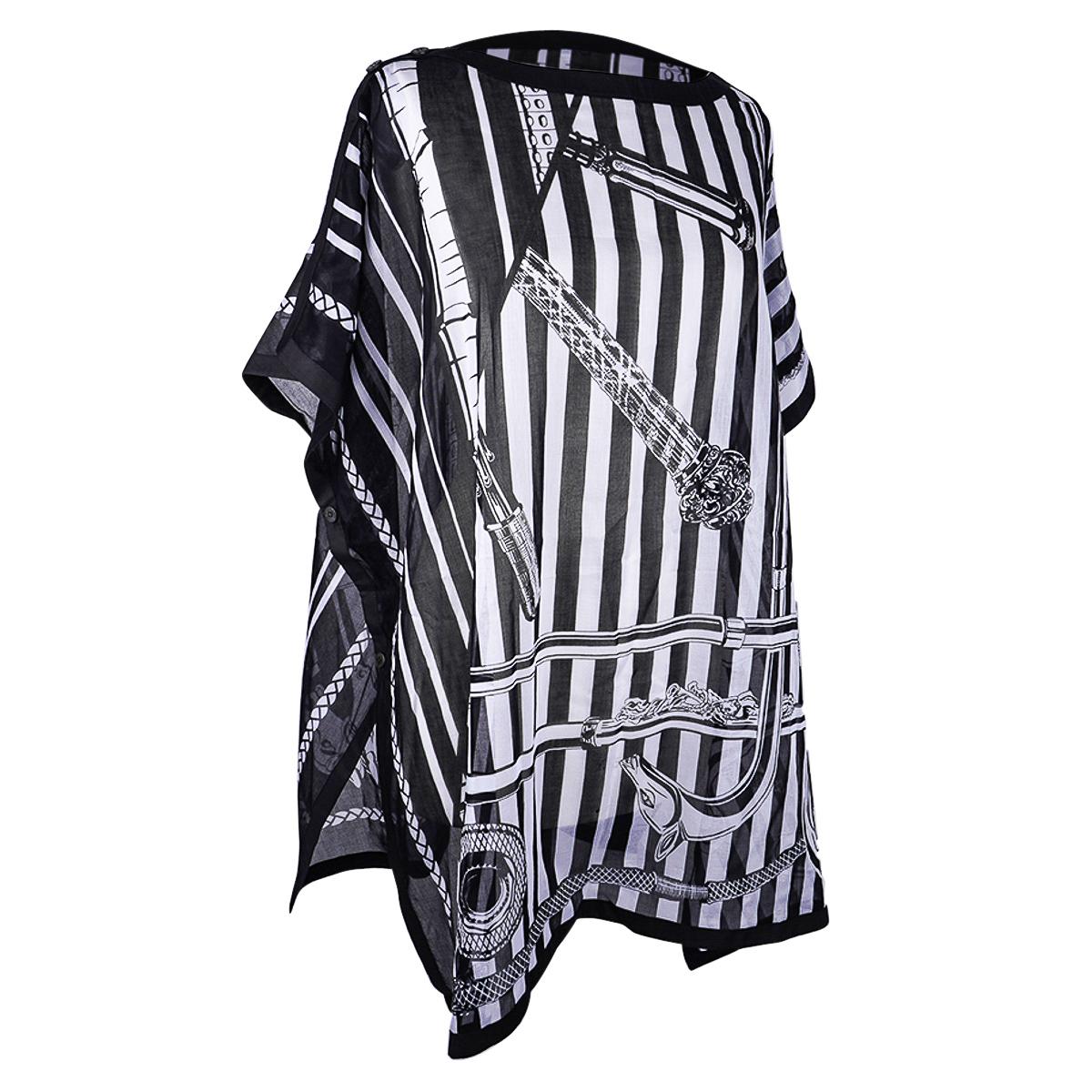 Mightychic offers an Hermes Tunique de Plage featured in Cannes et Cannes print.
This beautiful Black and White bather cover is airy light cotton voile.
Clou de Selle engraved Black Mother of Pearl buttons at the shoulder and along each side.
Band