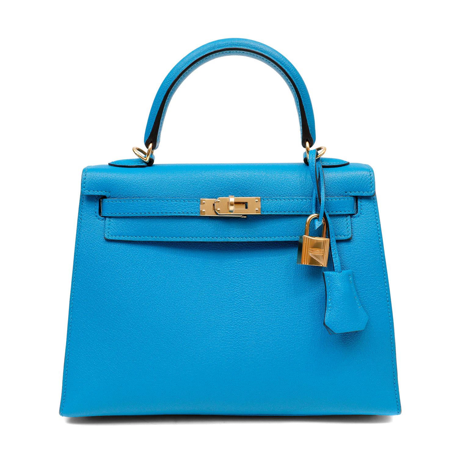 This authentic Hermès Turquoise Blue Chevre 25 cm Kelly is in pristine unworn condition with the protective plastic intact on the hardware.  Perfectly scaled in the 25 cm silhouette, this demure Kelly easily holds a phone and other