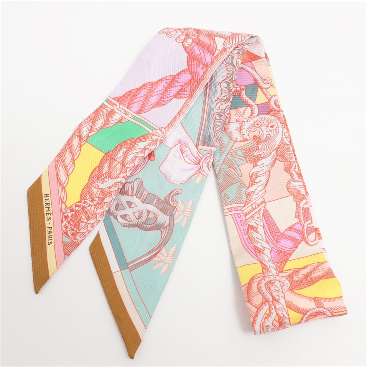 The Hermès Twilly Cavalleria d'Etriers in Pink is a luxurious and versatile accessory that adds a touch of elegance to any ensemble. Crafted from high-quality silk twill, the Twilly scarf features a vibrant pink hue adorned with intricate