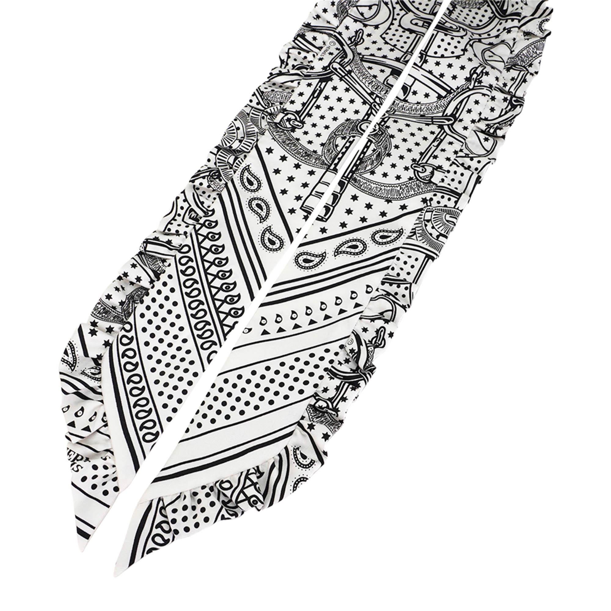 Mightychic offers an Hermes Twilly Eperon d'Or Bandana ruffled trim featured in Blanc and Noir.
The ruffled trim sets the tone for a feminine sprit.
Designed by Henri d'Origny.
This iconic Hermes accessory can be worn in a myriad of ways to add a