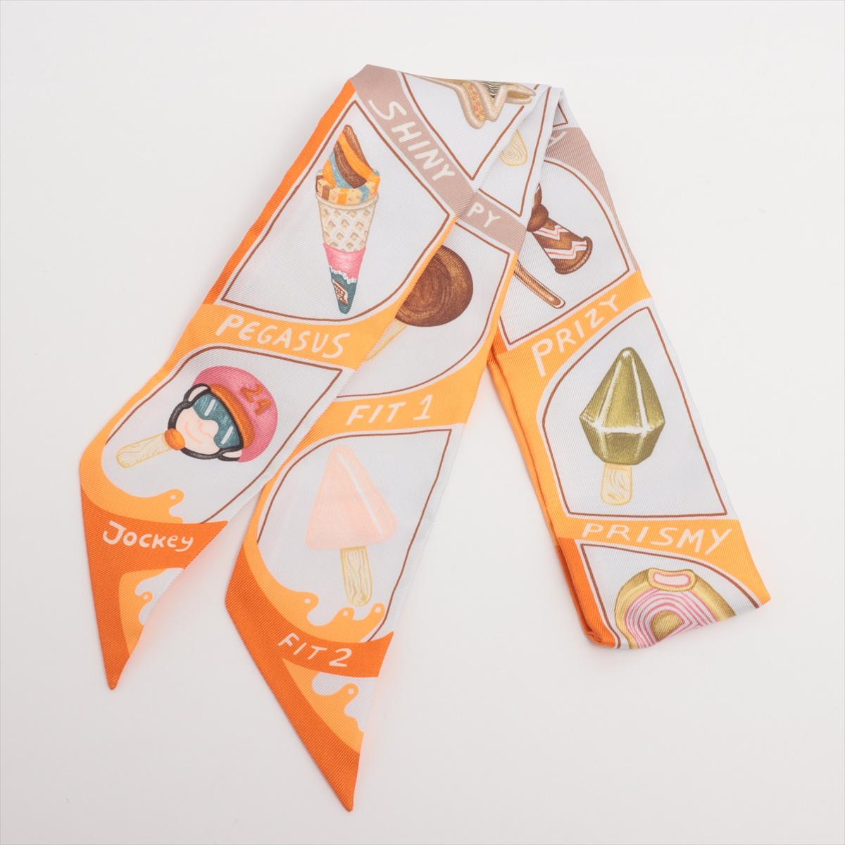 The Hermès Twilly Funny Ice Cream Silk in Orange x White is a playful and elegant accessory featuring a whimsical print on luxurious silk. Its vibrant orange and white color combination adds a fresh and dynamic touch to any outfit. Designed with