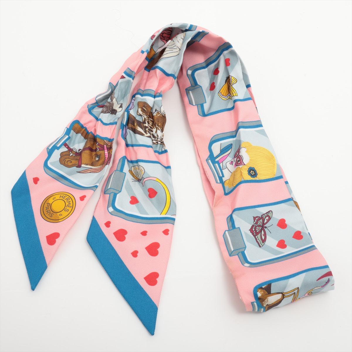 The Hermès Twilly Hermès Story Silk in Pink and Blue is a beautifully crafted accessory that showcases the brand’s signature elegance and artistry. Made from 100% silk, the Twilly features the intricate 