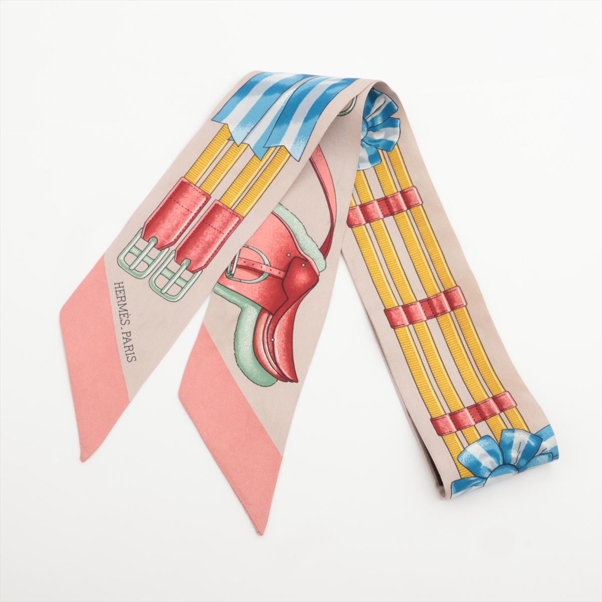 Le ruban de soie Twilly Jumping Ribbon en beige et rose d'Hermès est un accessoire délicat et stylé qui incarne l'élégance signature de la marque. Confectionné en 100 % soie, le Twilly arbore le motif Jumping Ribbon, inspiré du mouvement gracieux