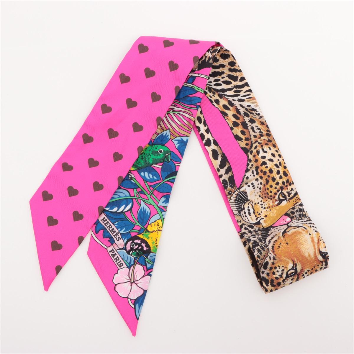 The Hermès Twilly Jungle Love Love in Hot Pink is a vibrant and romantic silk accessory that brings a bold splash of color and emotion to any look. Featuring the beloved Jungle Love design reimagined with a heartwarming twist, it showcases a pair of