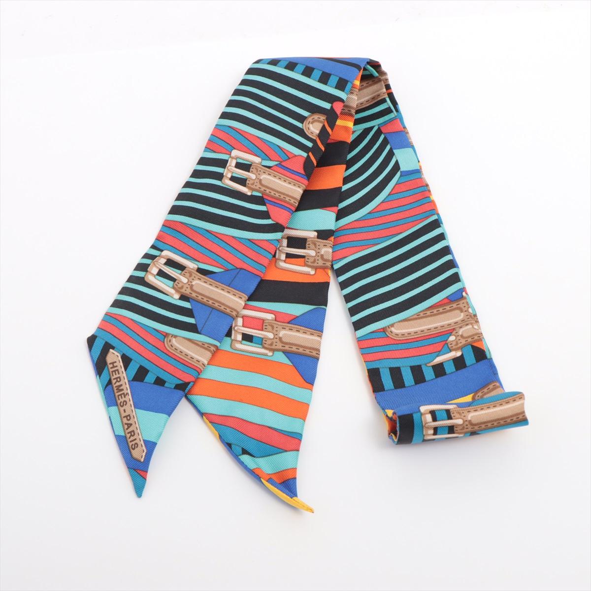 The Hermès Twilly Les Sangles Scarf in Multicolor Silk showcases an intricate design inspired by equestrian harnesses and straps, a recurring motif in Hermès' heritage. Crafted from 100% silk, the vibrant Twilly features a dynamic interplay of