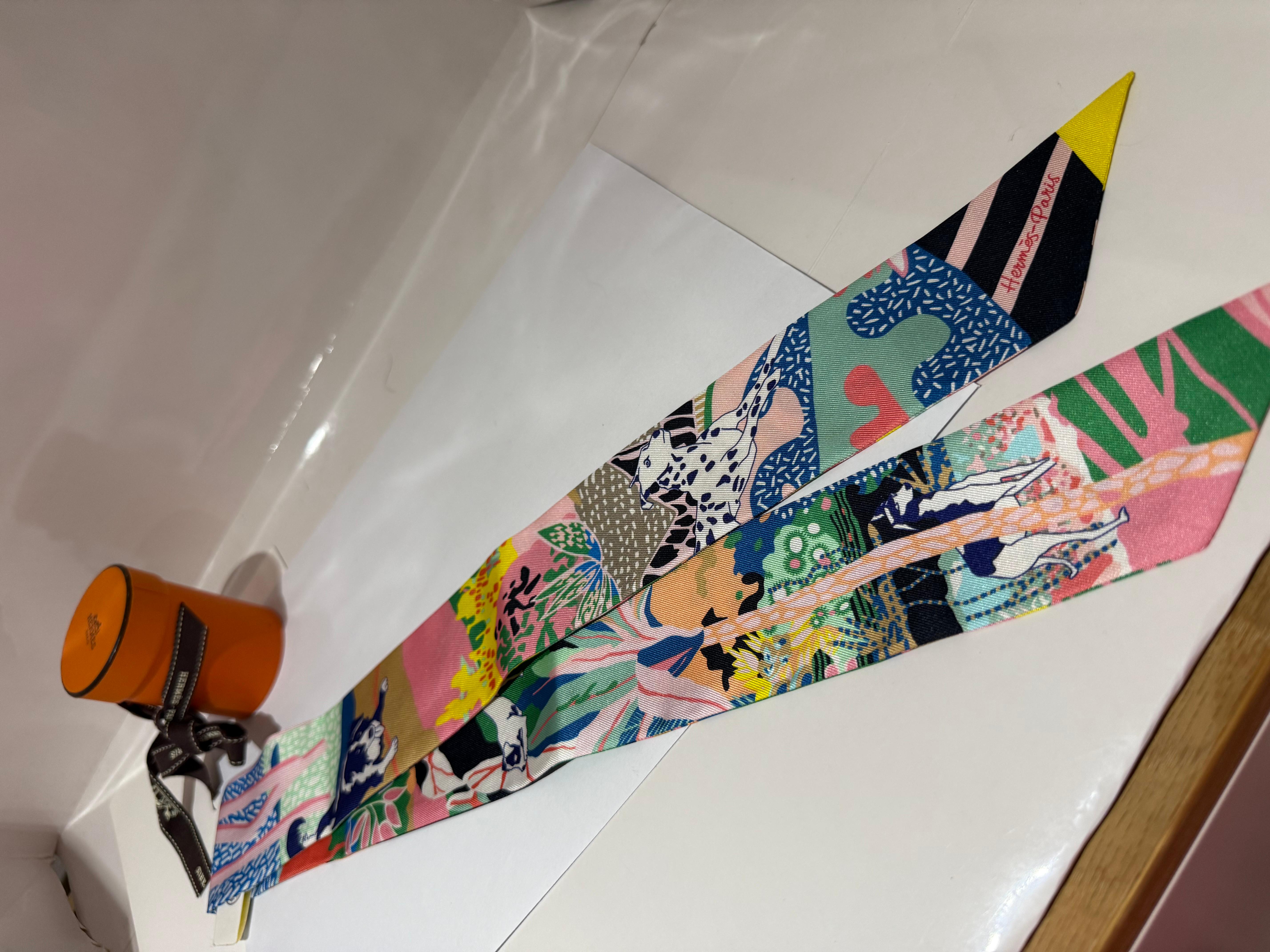 HERMÈS Twilly En Liberte Multi-color Silk scarf. With box and ribbon. With cute dog motives. Very nice gift!