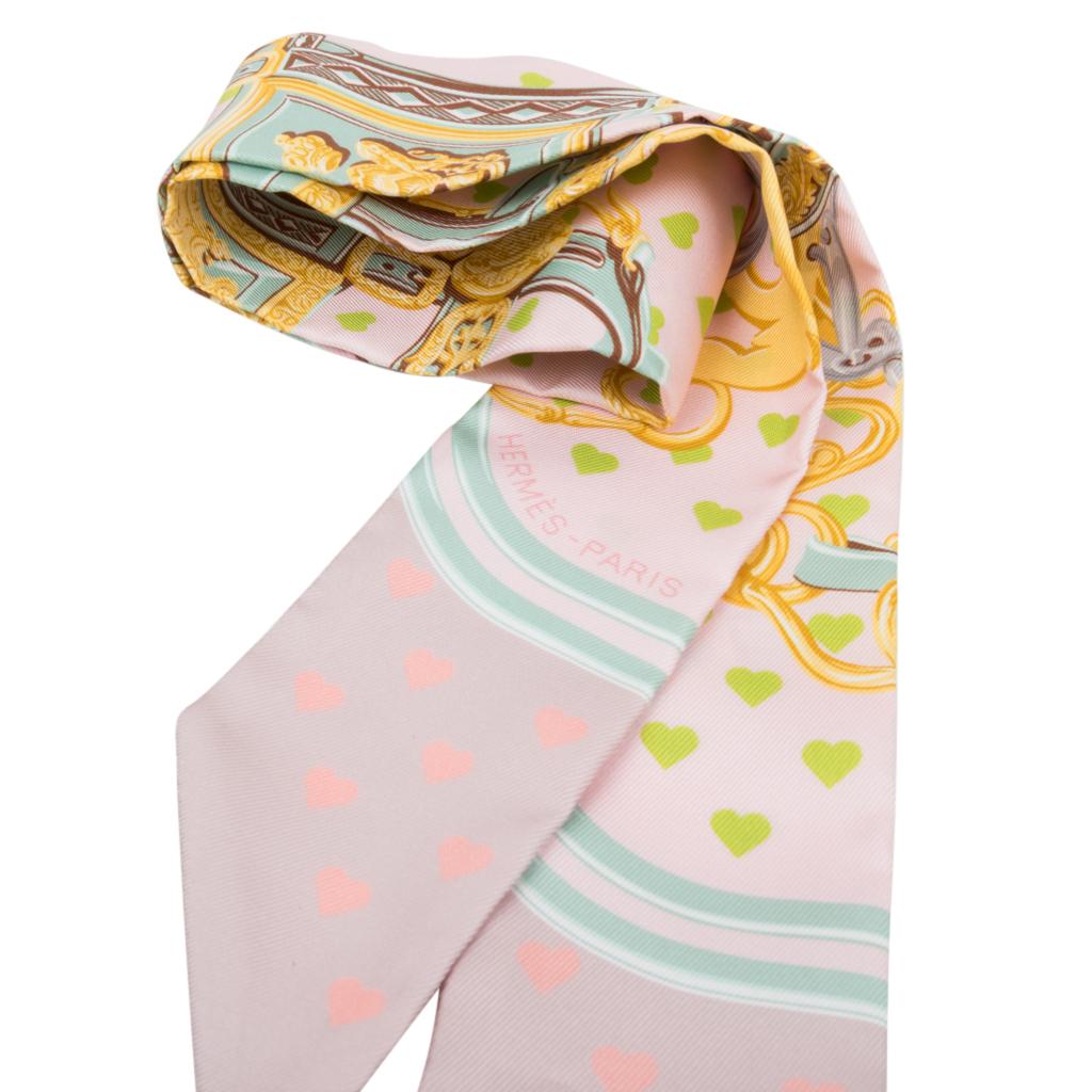 Guaranteed authentic Hermes silk scarf Twilly Love Heart Brides de Gala limited edition.
Beautiful soft Parme, Vert D'Eau and Vieux Rose design creates this exquisite scarf.
This print is the best selling scarf of Hermes for all time. 
Comes with