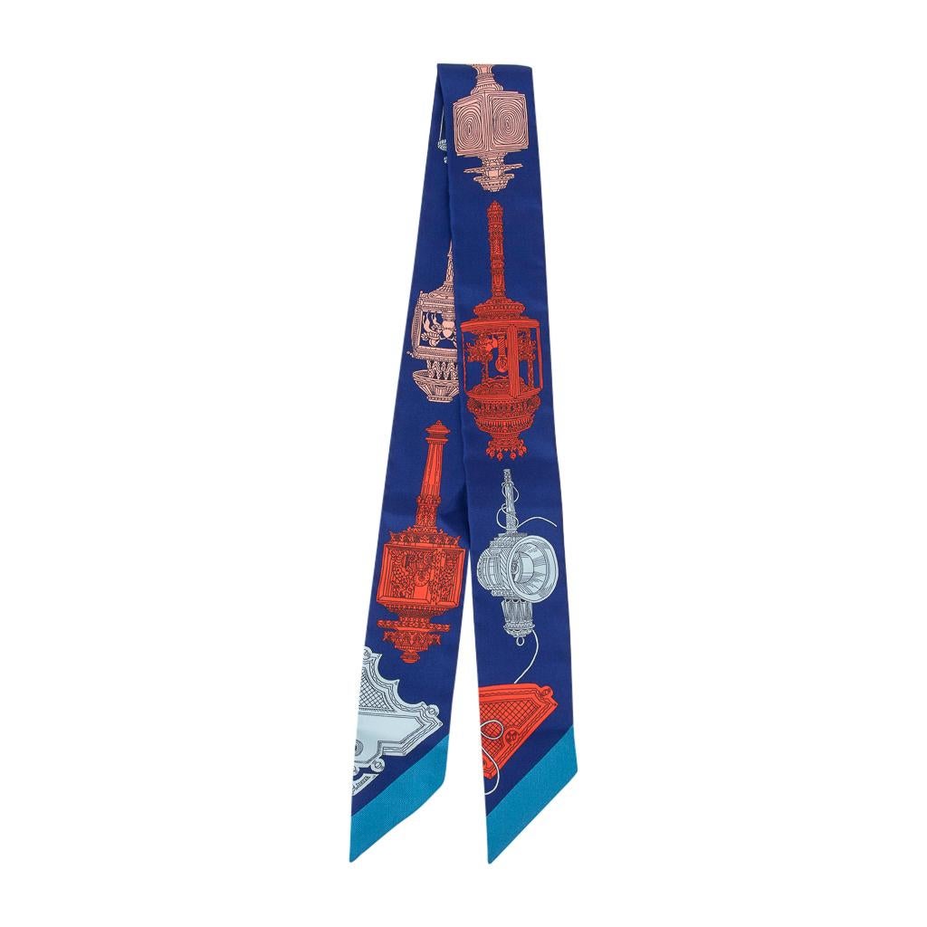 Guaranteed authentic Hermes Twilly silk scarf features Merveilleuses Lanternes in a rich palette of Blue Indigo, Orange and Blue Glacier.
This iconic Hermes accessory can be worn in a myriad ways to add a playful touch to your wardrobe.
And of