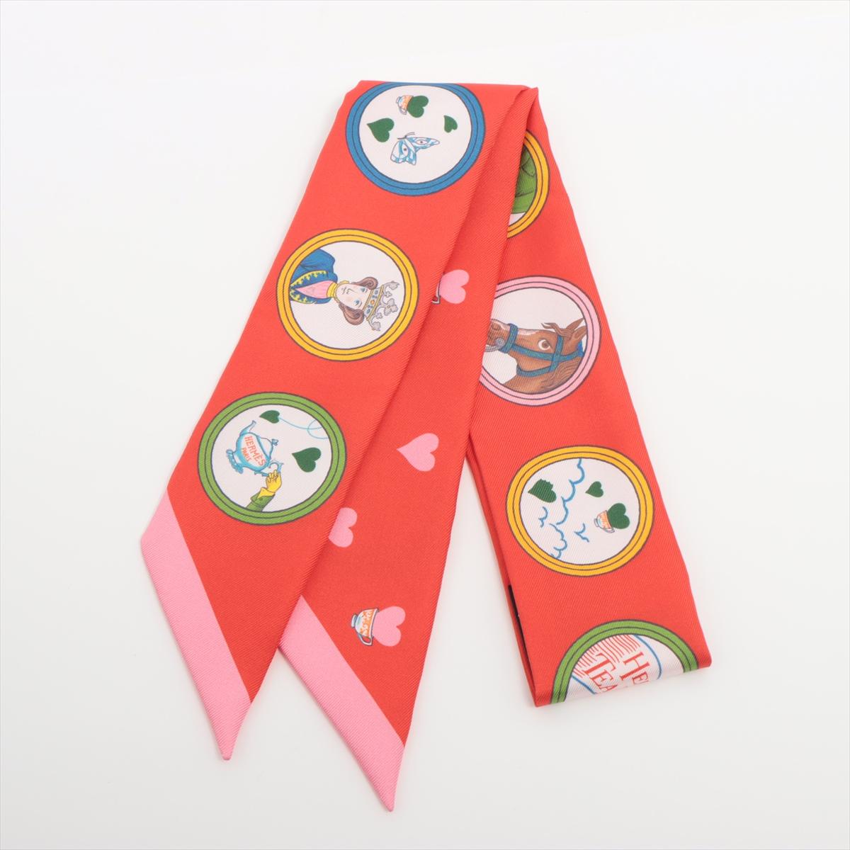 The Hermès Twilly Tea Time in Red is a whimsical and elegant silk accessory that brings a touch of playful sophistication to any ensemble. Featuring a charming design inspired by the ritual of tea time, the scarf is adorned with delicate teapots,