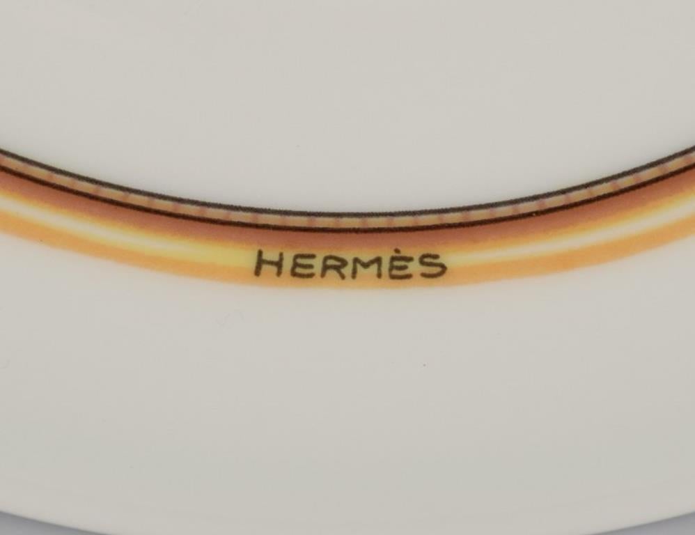 Hand-Painted Hermès. Two porcelain plates with bird motifs. 