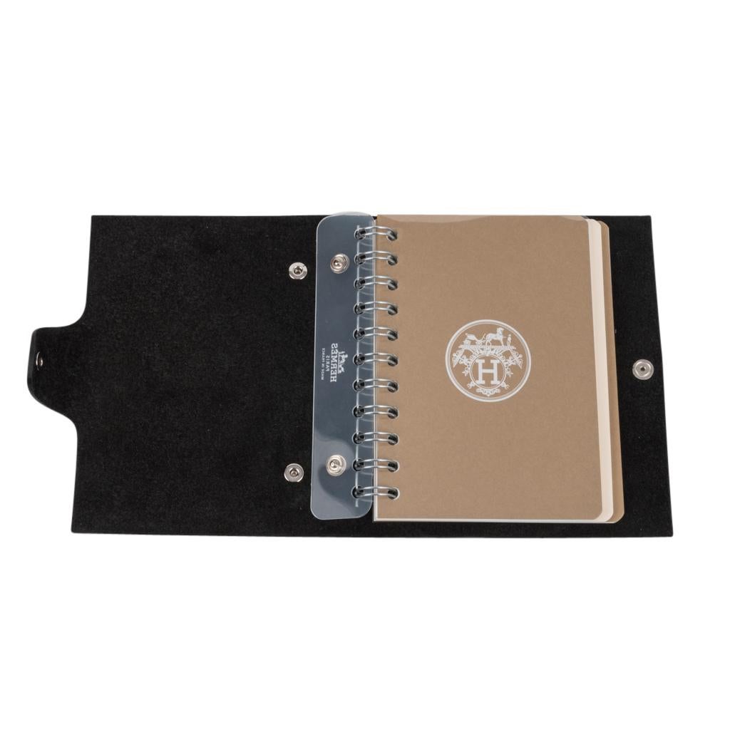 Guaranteed authentic Hermes Ulysse small model notebook cover features Black togo leather.
Palladium Clou de Selle  snap. 
Comes with a new Ulysse Arpege notebook refill.   
Charming refill as each unique hue represents a season.  This one is