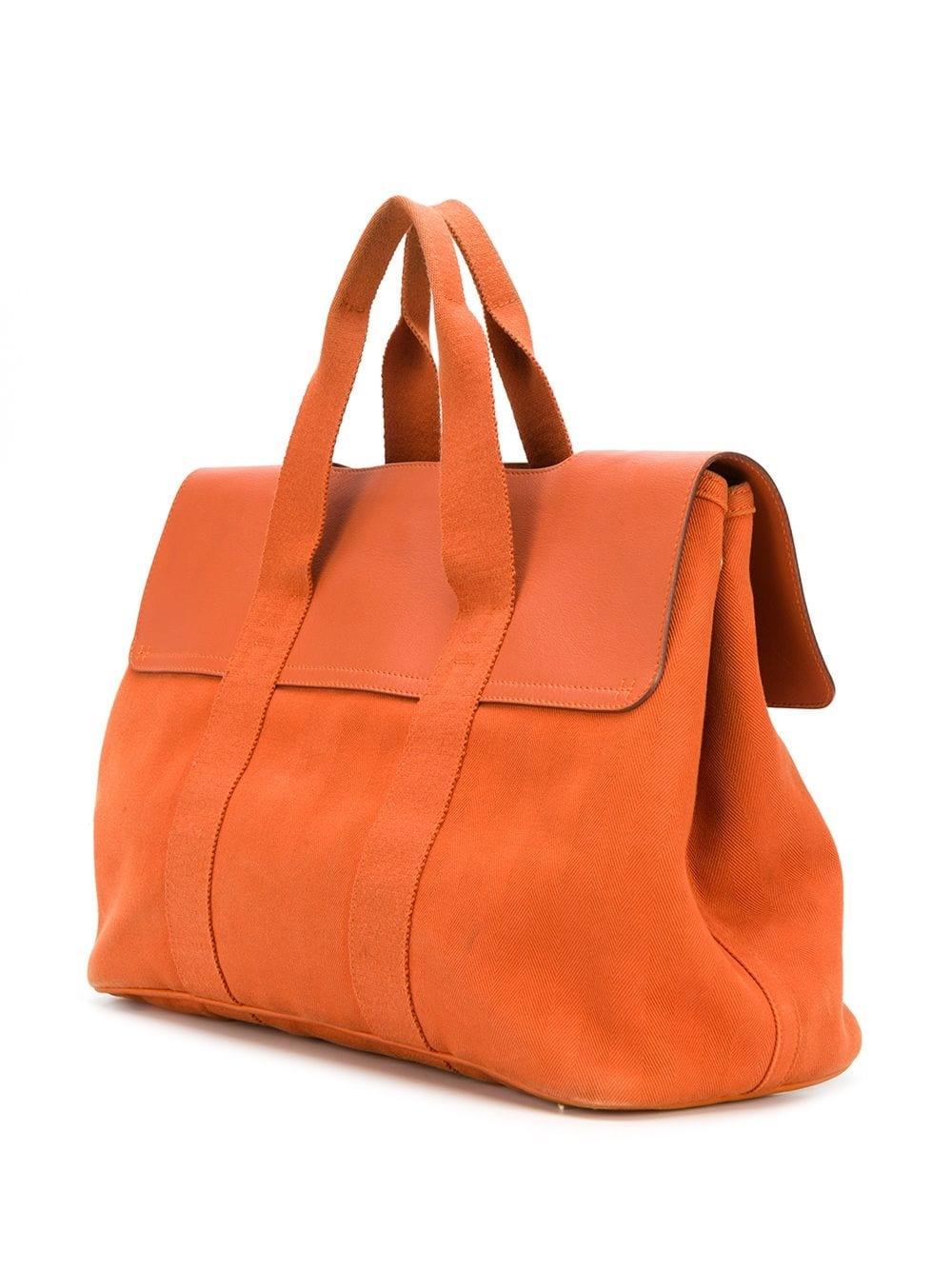 Adding a twist to the traditional Hermès Valparaiso tote bag, this highly collectable rarity combines contrasting panels of durable brick-orange leather with lightweight toile, silver-toned metal accents and tonal stitching. Synonymous with the