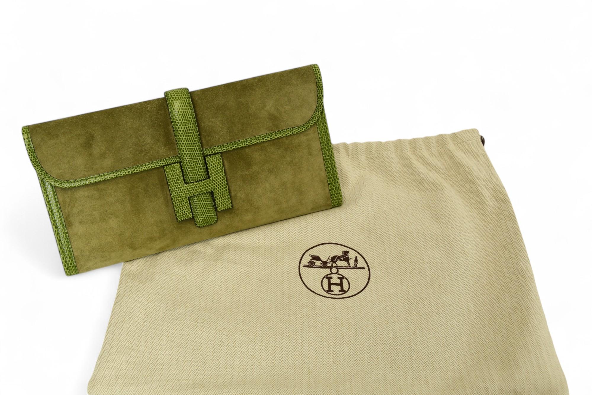 Diese atemberaubende Hermès Jige Elan 29 Clutch ist aus prächtigem Bleu Ocean Veau Doblis Wildleder gefertigt und wird durch kontrastierende Eidechsenbesätze für ein kühnes und luxuriöses Finish ergänzt. Die langgestreckte Silhouette wird durch den