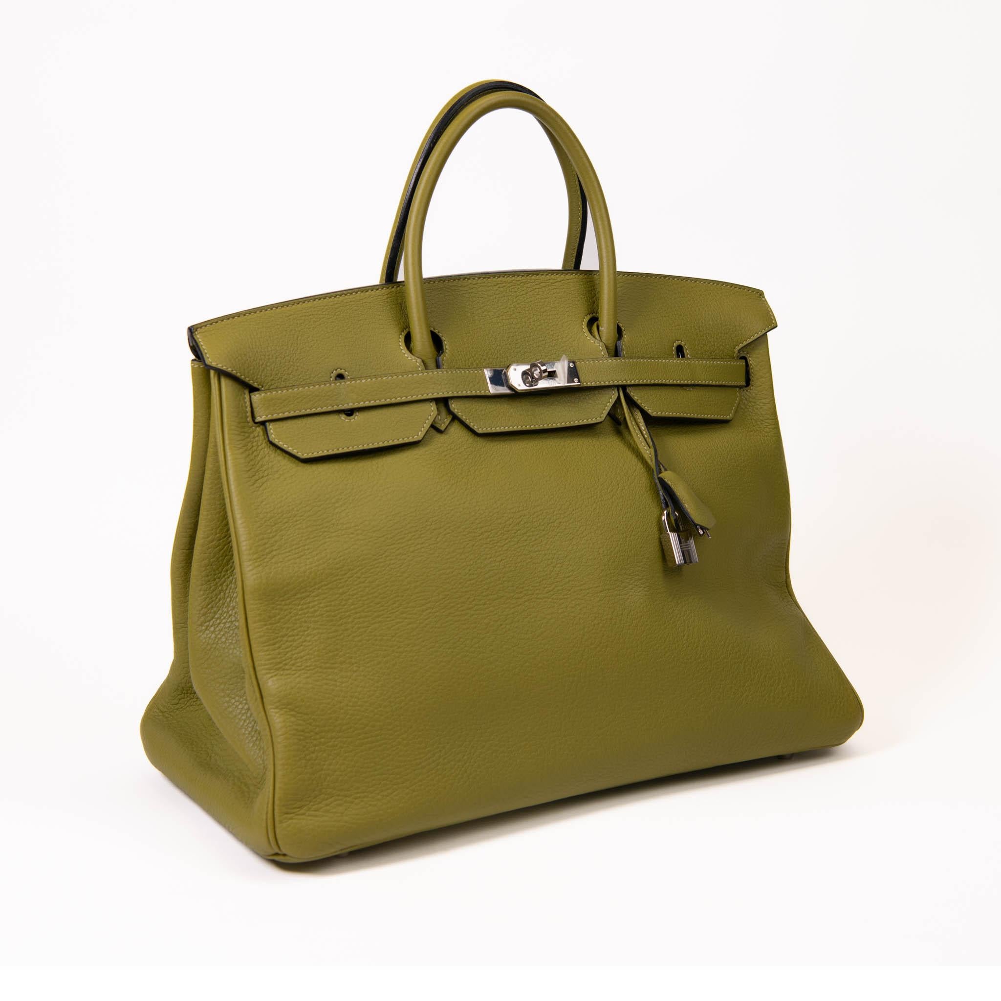 100% authentisch

Diese stilvolle Tote ist aus Kalbsleder in Grün gefertigt. Die Tasche verfügt über gerollte Ledergriffe, dunkelbraune Harzbesätze, eine Vorderklappe und einen Riemenverschluss mit Palladiumbeschlägen, einschließlich Riemengliedern
