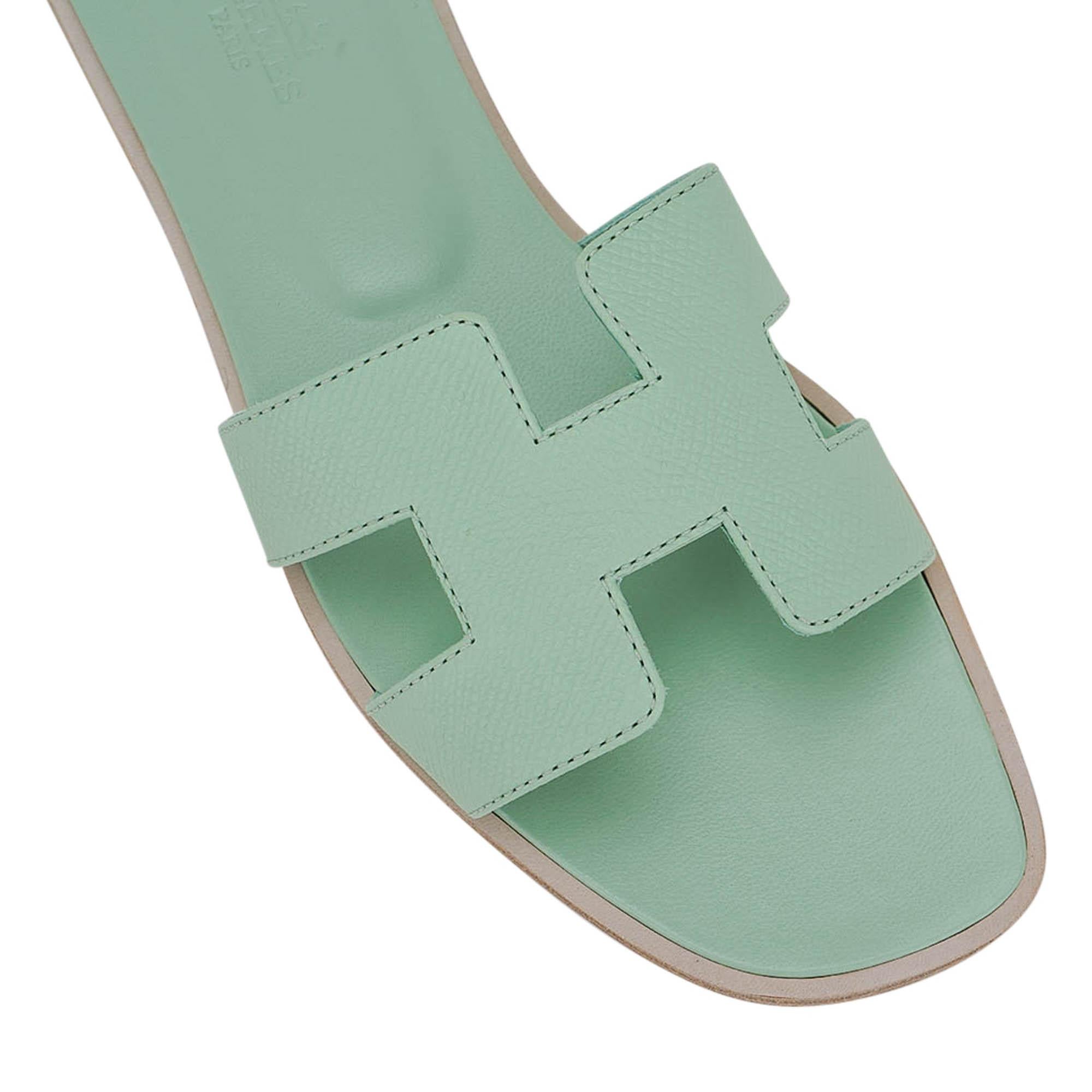 Mightychic offers a pair of Hermes Oran flat sandals featured in Vert D'Eau.
This stunning limited edition Hermes Oran slide sandal is in a soft drink of water hue - stunning.
The iconic H cutout over the top of the foot.
Matching embossed calfskin