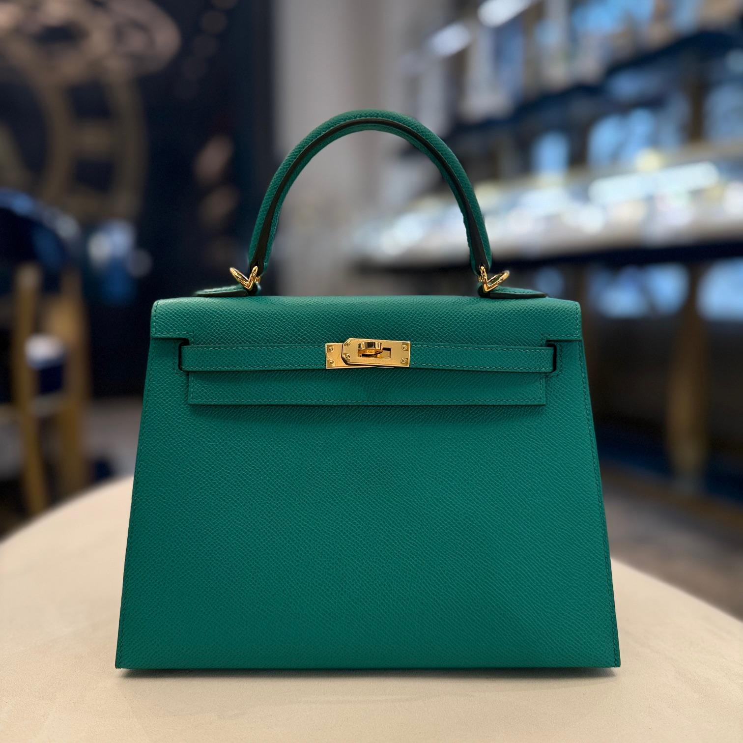 Jewels Aficionado offers The Hermès Kelly Sellier 25 in Vert Jade Epsom leather blends elegance with modern sophistication. Its rich dark green hue enhances the structured silhouette, making it a bold statement piece. Epsom leather ensures