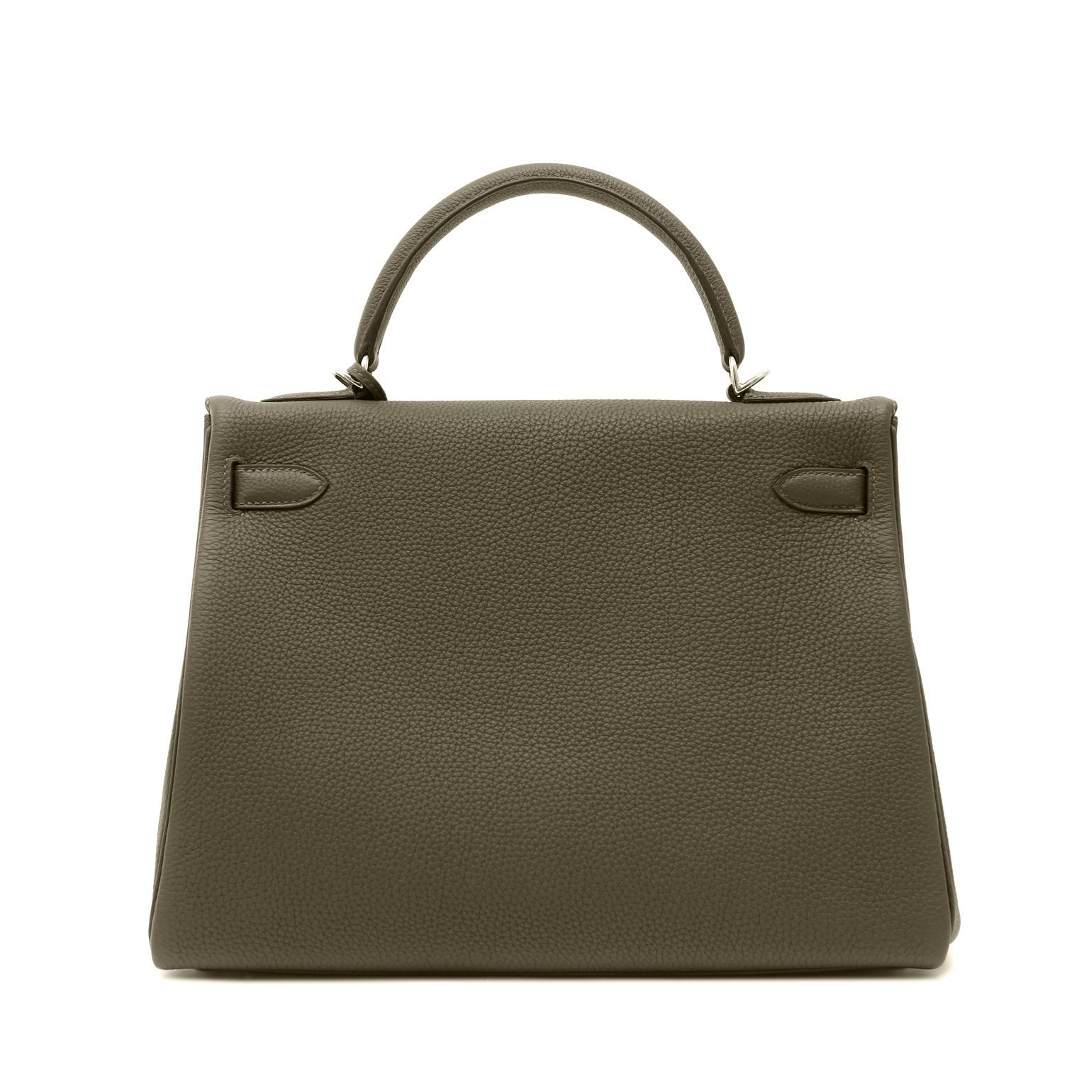 This authentic Hermès Vert Maquis Togo 32 cm Kelly is in pristine unworn condition with the protective plastic intact on the hardware.  A new green from Hermès, this dark grey green is a fabulous neutral.  

Textured and soft to the hand, Togo