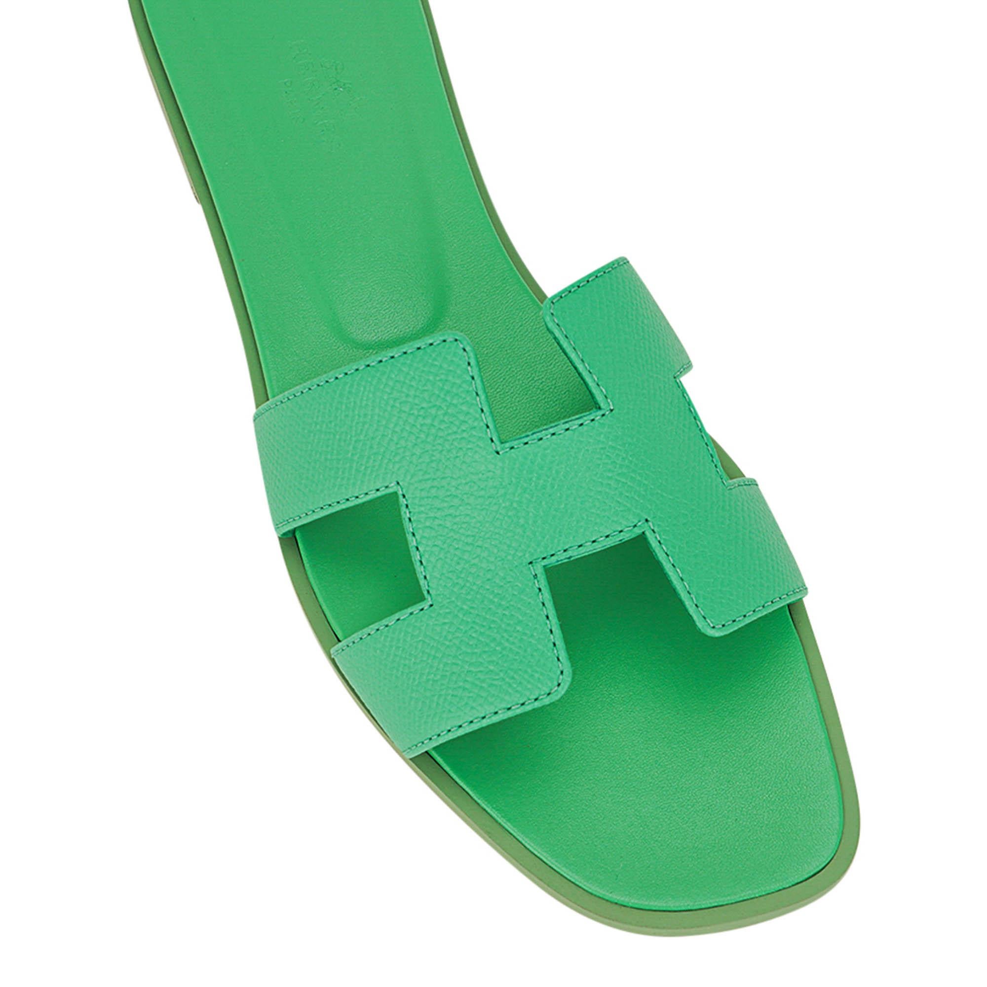 Mightychic offers Hermes Oran flat sandals featured in Vert Pomme.
This fresh green Hermes Oran slide sandal is like a cool breeze on a summer day.
The iconic H cutout over the top of the foot.
Matching embossed calfskin insole.
Wood heel with