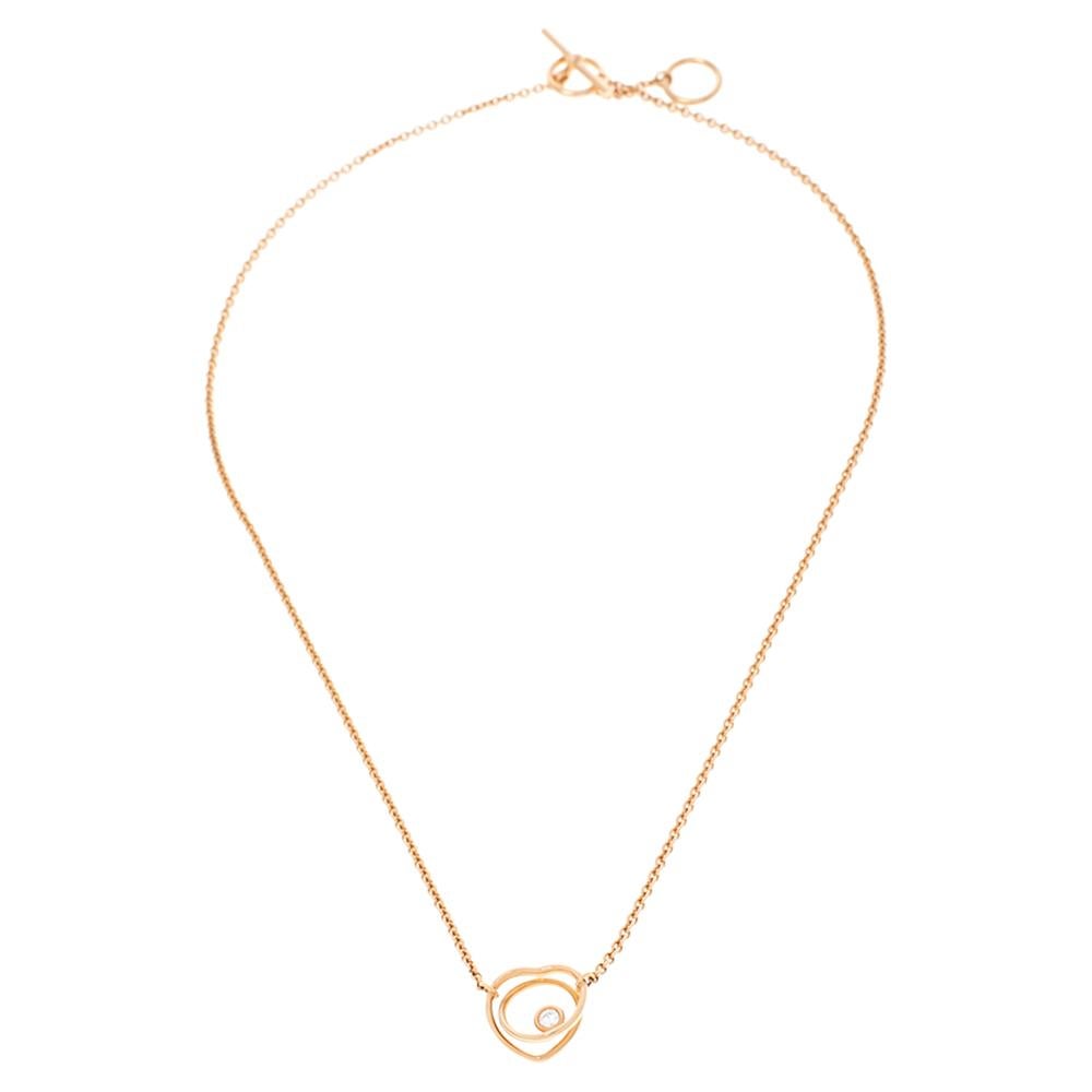 Give your everyday looks a touch of luxury with this Vertige Cœur necklace from the house of Hermes. Designed from 18k rose gold, this necklace features a double ring pendant with one of them shaped like a heart and decked with a single shining