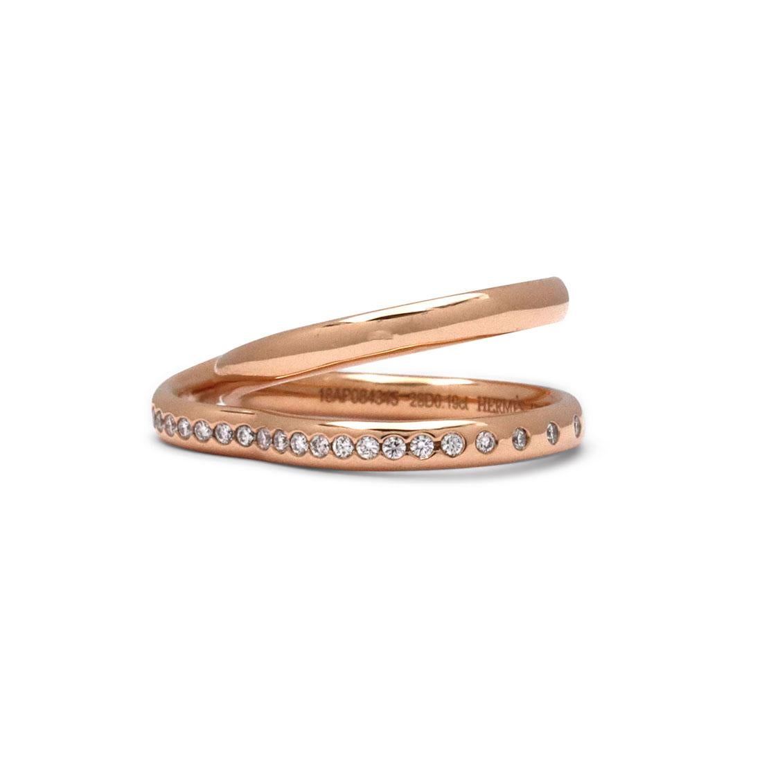 Authentic Hermes Vertige Coeur ring crafted in 18 karat rose gold and designed in the shape of a double ring. The second ring is heart-shaped and is set with round brilliant cut diamonds with an estimated total carat weight of 0.19. Signed Hermes,