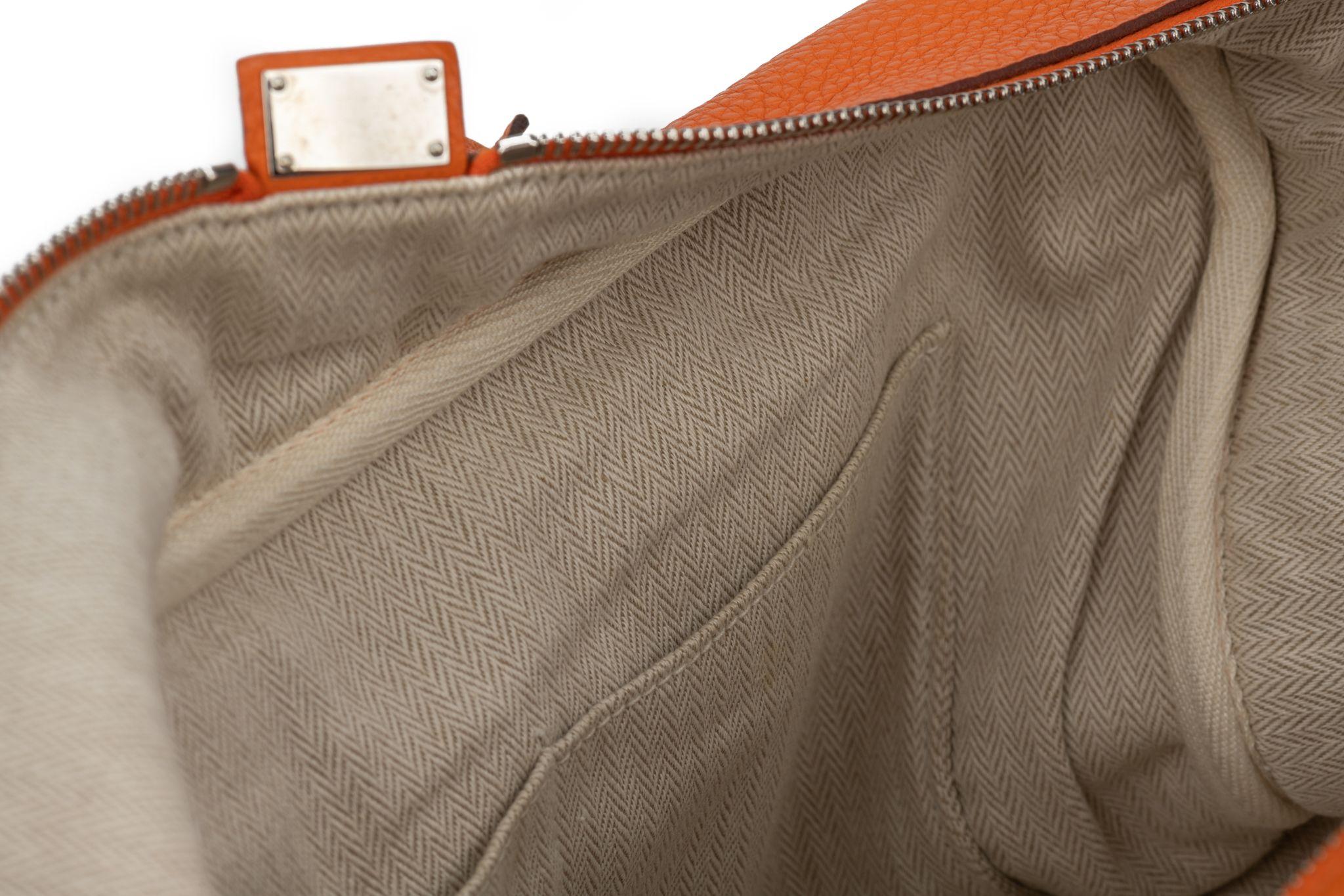 HERMÈS Victoria II 35 made of clemence leather in orange. The bag has palladium silver hardware and a beige canvas interior. The handle drops 8'. The item comes with the original dustcover.