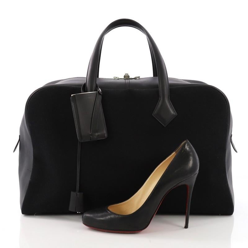 This Hermes Victoria II Handbag Toile 43, crafted in Noir black Toile and Evercalf leather, features dual top leather handles, protective base studs, and Palladium hardware. Its zip closure opens to a Beige Canvas interior with slip pockets. Date
