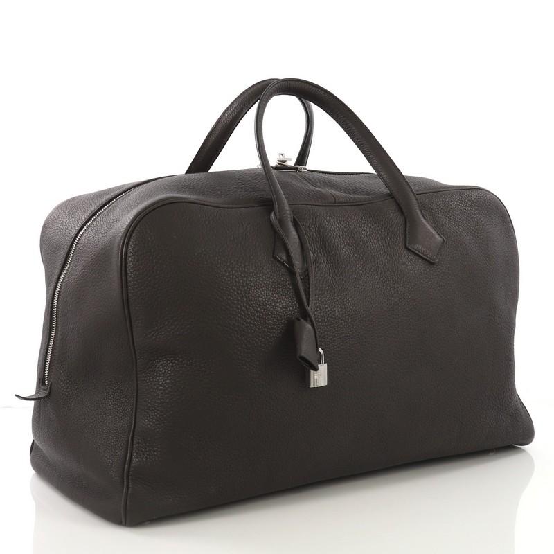 This Hermes Victoria II Travel Bag Clemence 50, crafted in Ebene brown Clemence leather, features dual top leather handles and palladium hardware. Its zip closure opens to a beige canvas interior. Date stamp reads: K Square (2007).

Estimated Retail