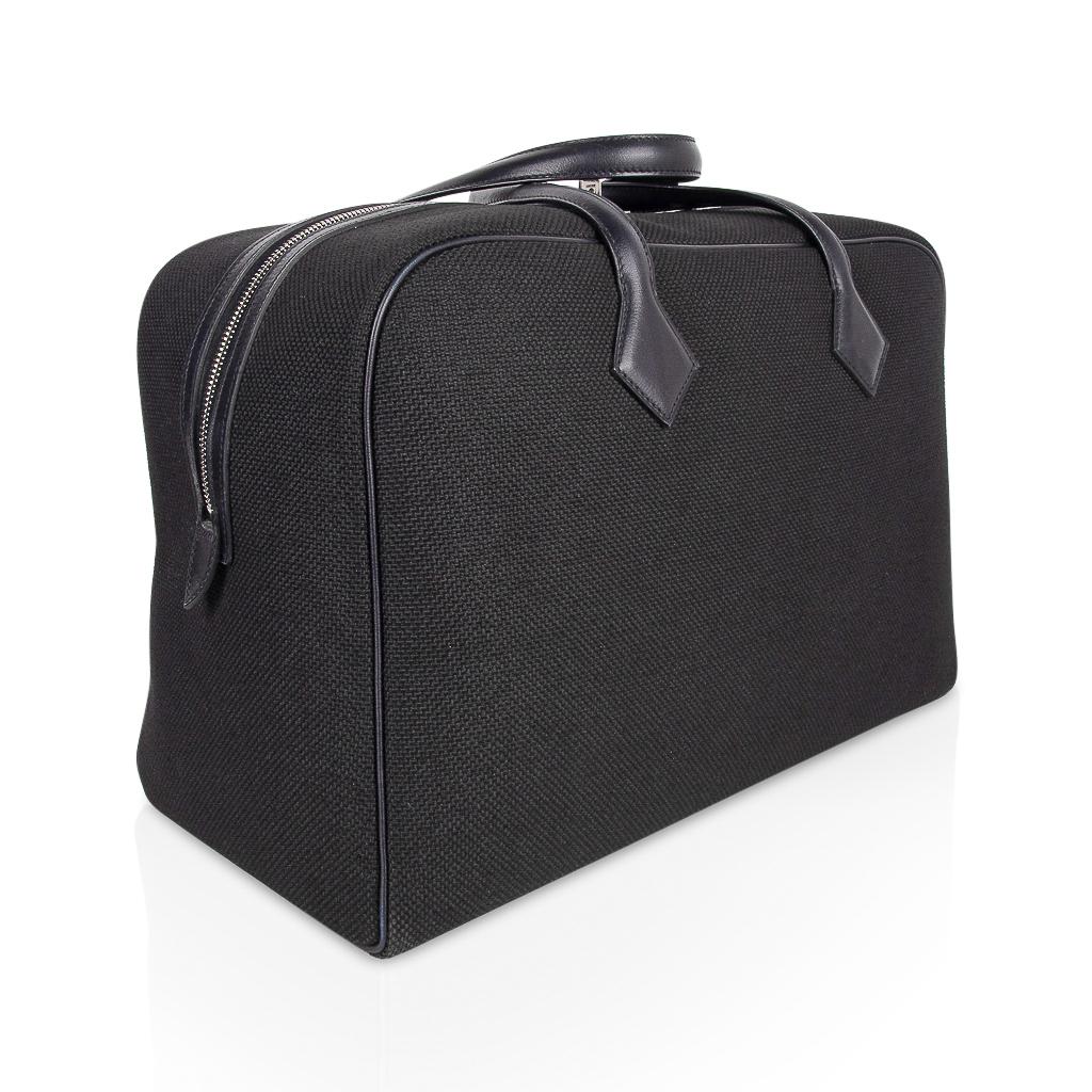 Guaranteed authentic chic Hermes Victoria ll Fourre-Tout 43 travel bag features Black Toile and leather trim.  
Leather handles and trim with palladium hardware.
Light weight with sleek clean lines.   
This beautiful travel bag is a true Hermes