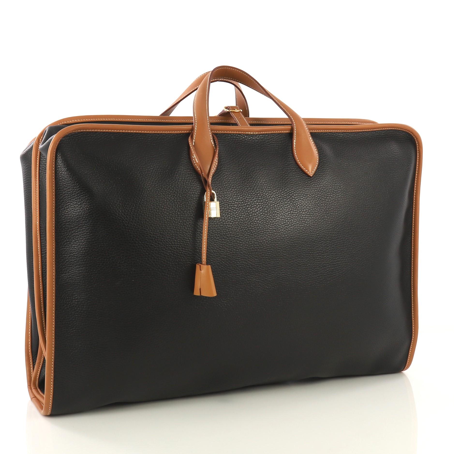 This Hermes Victoria Suter Garment Bag Leather, crafted from Noir black Ardennes and Natural brown Chamonix leather, features dual flat handles and gold hardware. Its zip closure opens to a beige canvas interior. Date stamp reads: A (Square) 1997.