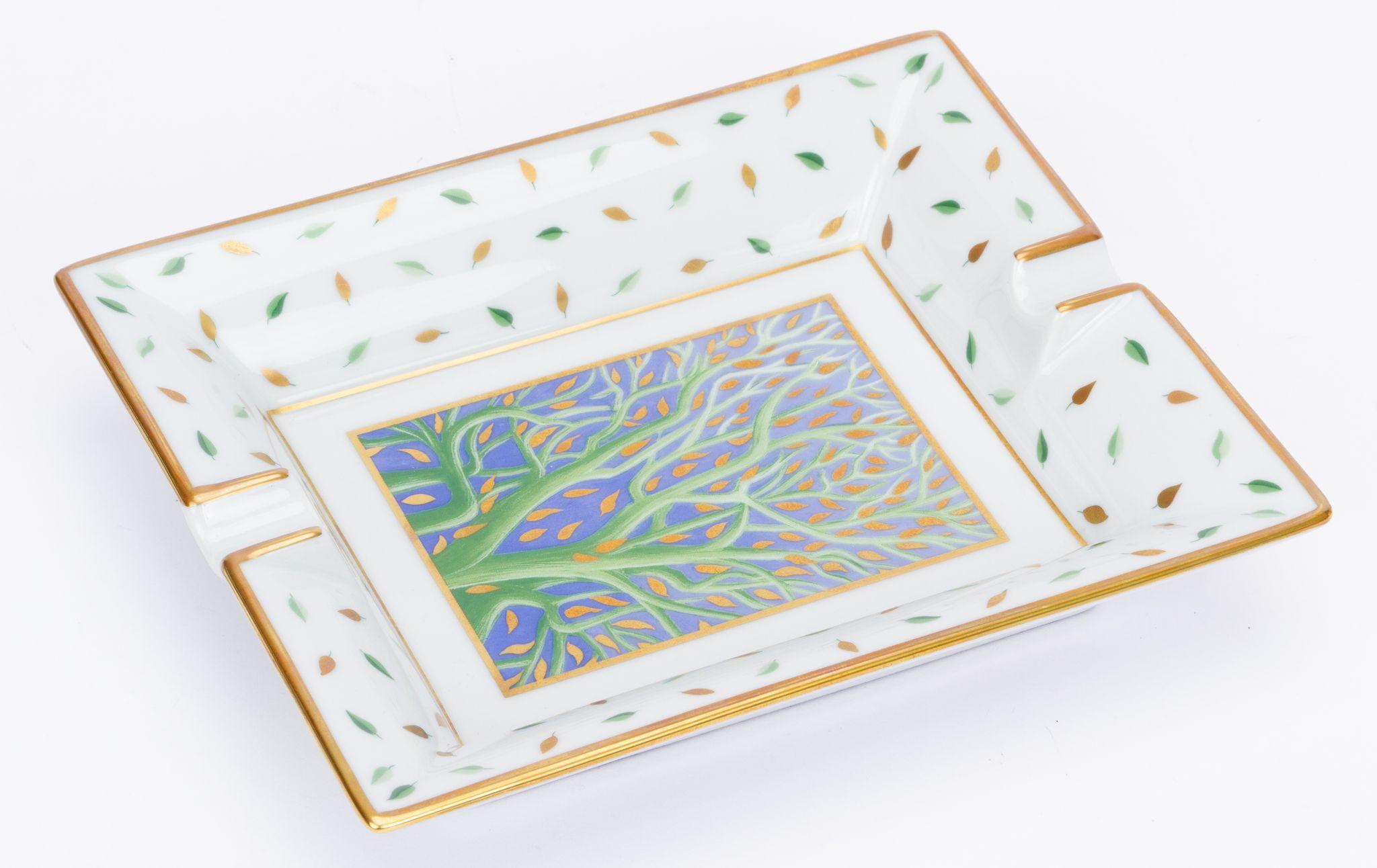 Hermès vintage ashtray in multicolor. The edges show multicolor leaves falling and in the center is branch of a tree with falling leaves. The piece is in excellent condition and comes with the original box.