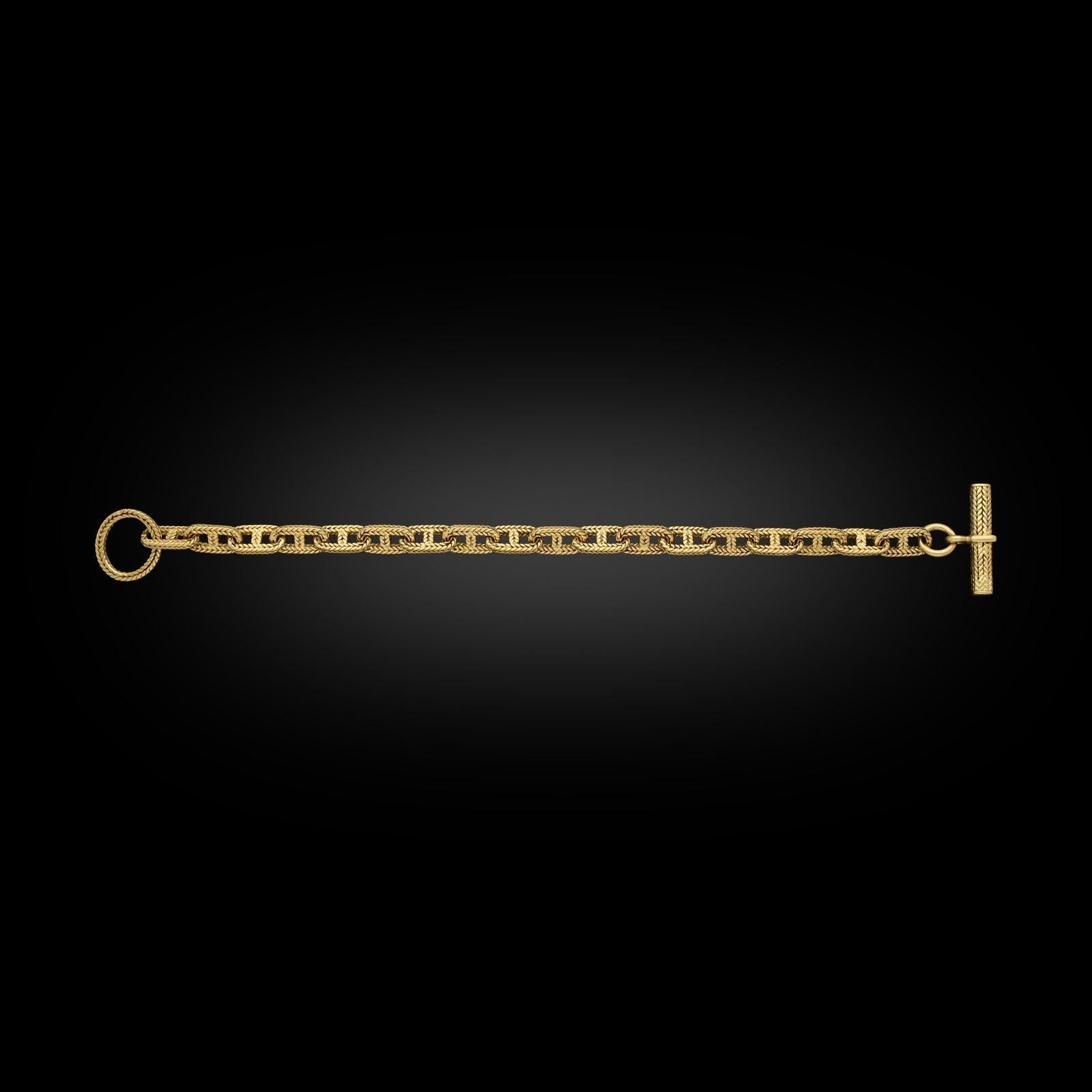 A stylish vintage gold Chaine d'Ancre bracelet by Hermès c.1960s, formed of eighteen uniform oval links each with central bar in textured rope twist 18ct yellow gold with a circular ring at one end and a bar at the other forming a toggle style