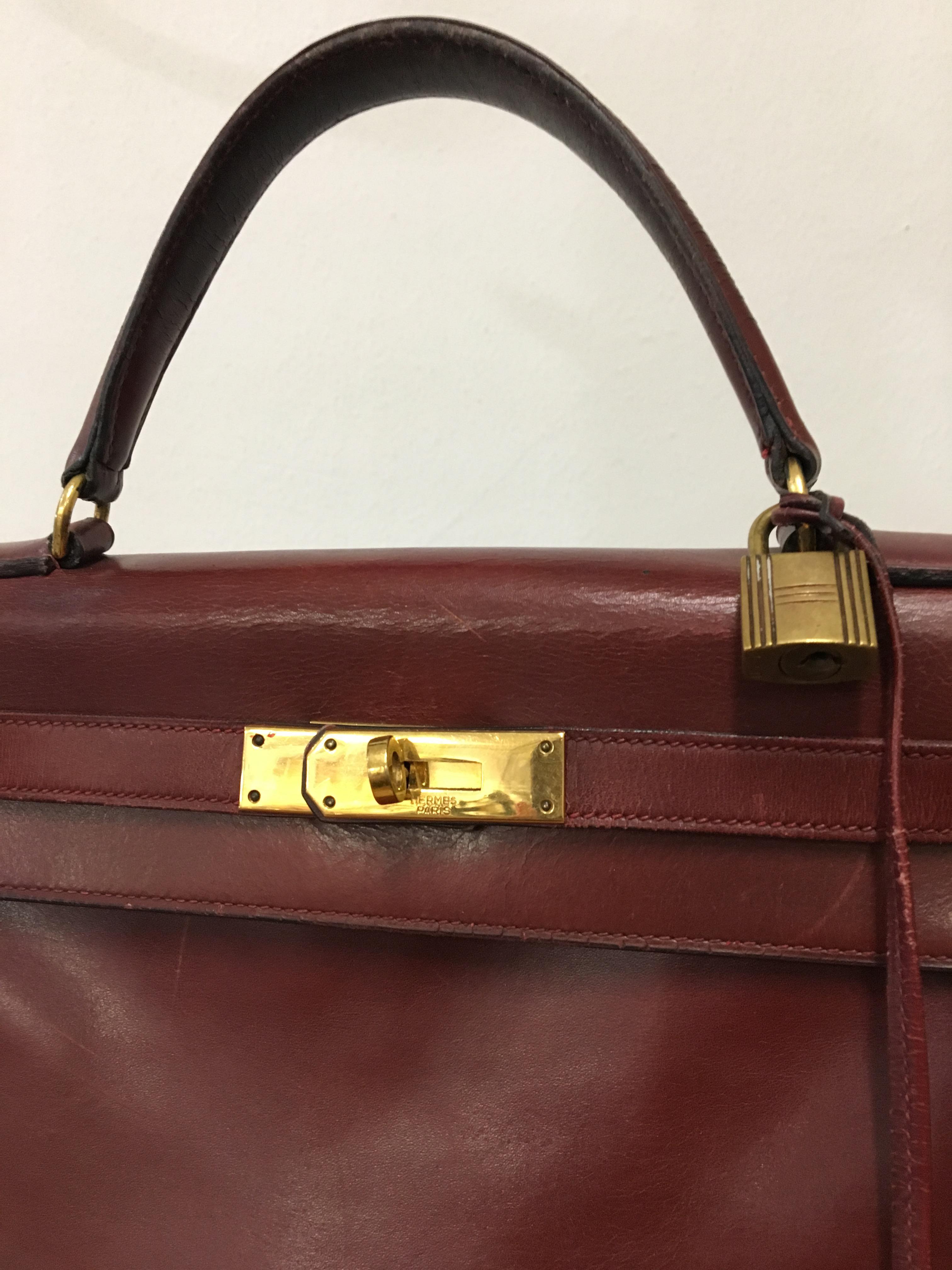 Vintage leather Kelly bag. Featuring a trapeze body, top flap closure with twist-lock strap fastening, gold-tone hardware, front embossed logo stamp, a detachable leather clochette, lock and two keys, single structured leather top handle.