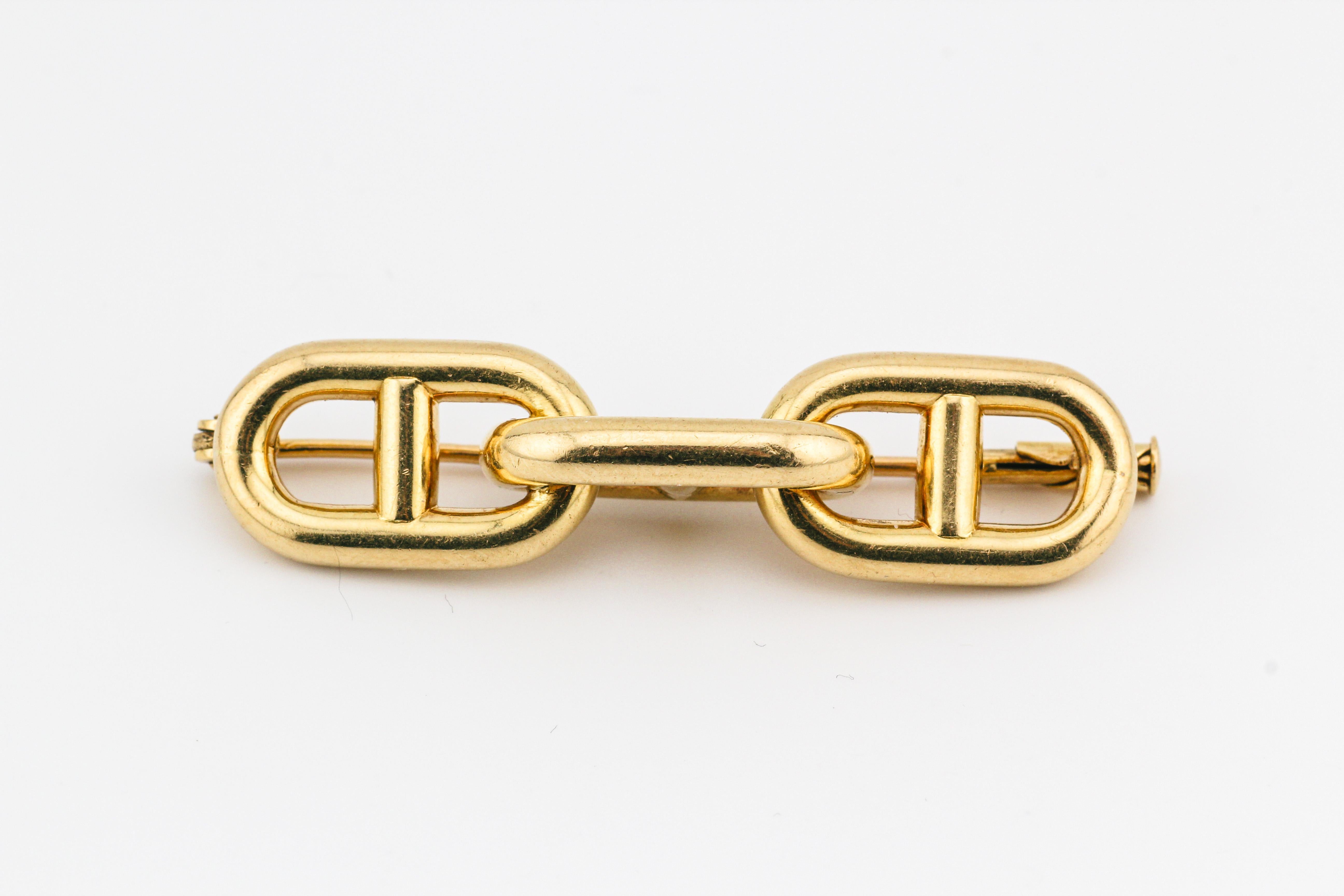 Elevate your style with the timeless allure of the Hermes Vintage 1970s Chaine D'Ancre 18k Gold Brooch. This exquisite piece from the renowned French luxury house Hermes is a testament to craftsmanship and enduring design.  Crafted in the 1970s,