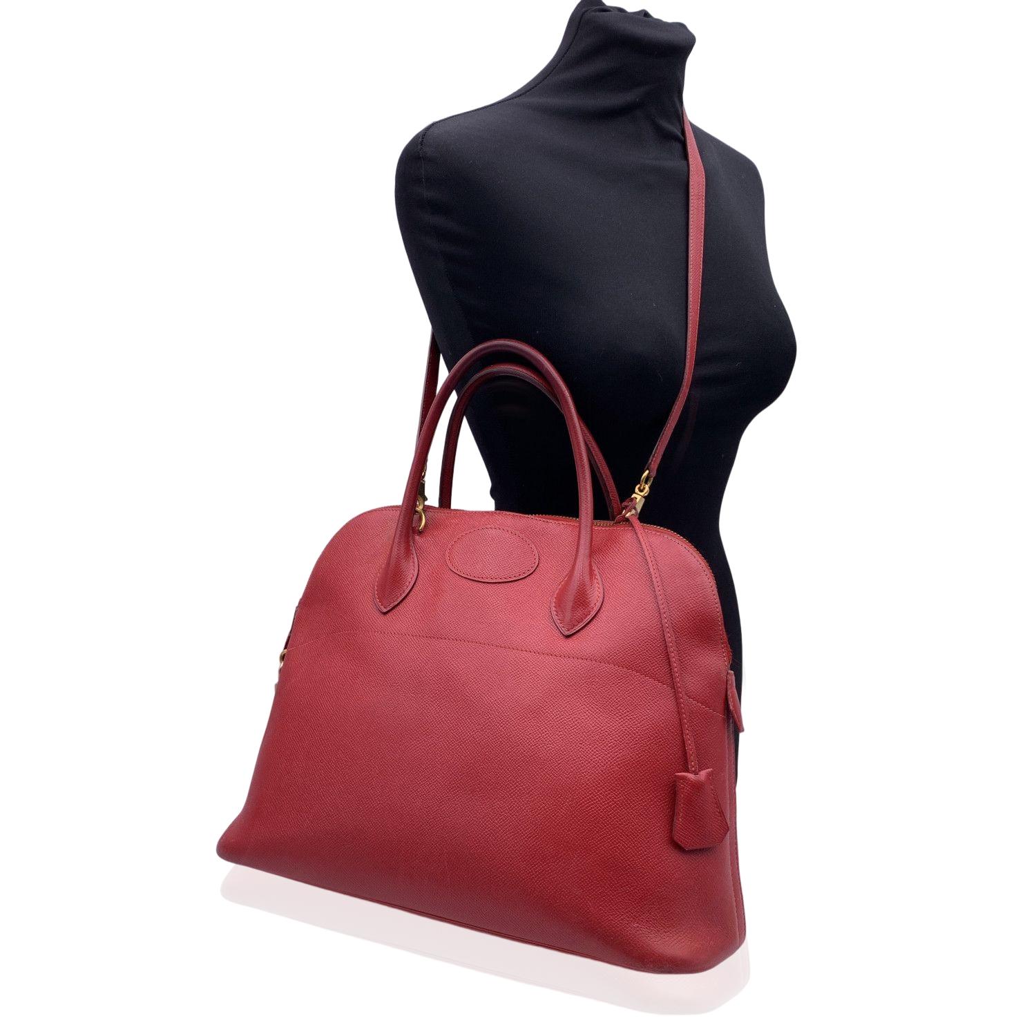 Sophisticated and timeless Hermes BOLIDE BAG crafted in red leather from the 1992 (blind stamp is 'V' encased in a circle). It features a doomed top with double top rolled leather handles and removable shoulder strap. Upper zipper closure. This