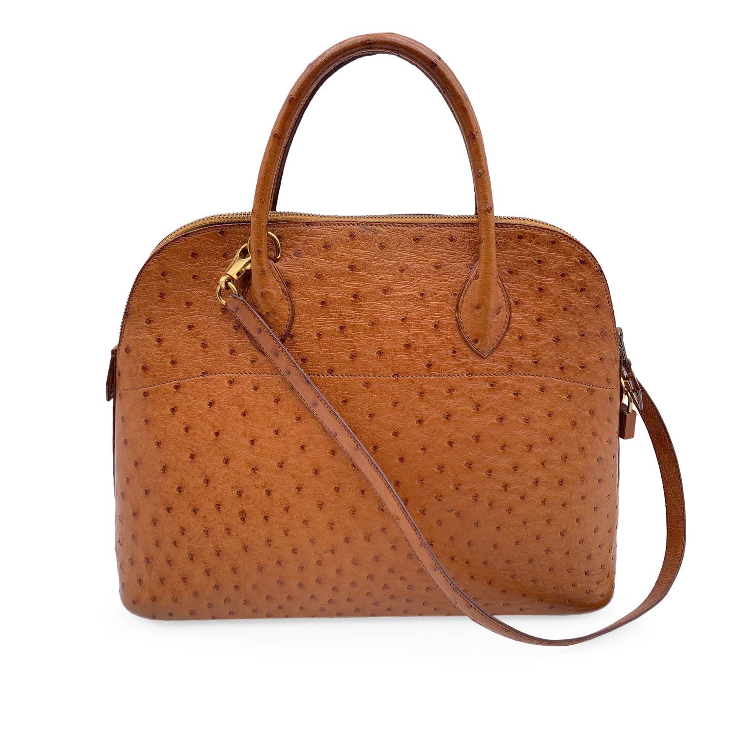 Sophisticated and timeless Hermes BOLIDE BAG crafted in tan ostrich leather from the 1992 (blind stamp is 'V' encased in a circle). It features a doomed top with double top rolled leather handles and removable shoulder strap. Upper zipper closure.