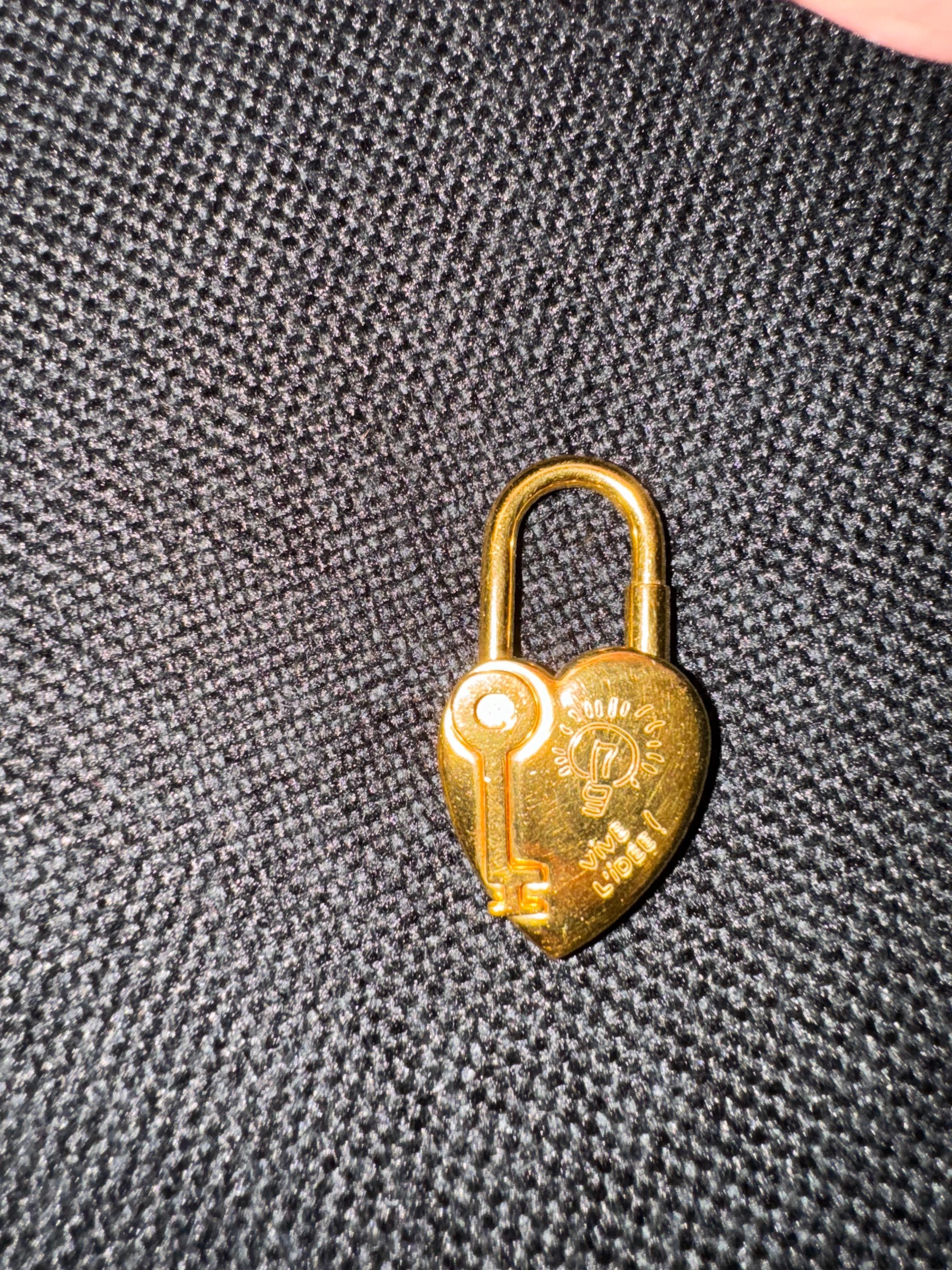 Beautiful vintage charm for bags or can be worn as pendant as well. Beautiful yellow gold color. Perfect way to accessorize your bag. Comes with its original dust bag and case. Twist lock system. Slight scratches and scuffing throughout.