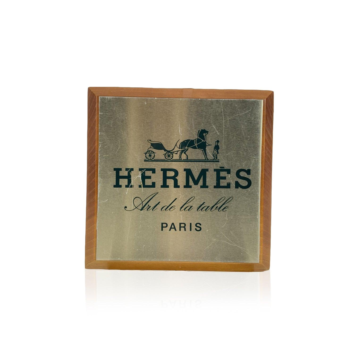 Vintage Hermes Regalaufsteller/Teller mit der Aufschrift 'Hermes Art de la table - Paris'. Quadratische Form. Hergestellt aus Holz, mit Oberseite aus hellgoldfarbenem Metall. Abmessungen: 6.5 x 6.5 inches - 16,5 x 16,5 cm Details MATERIAL: Holz