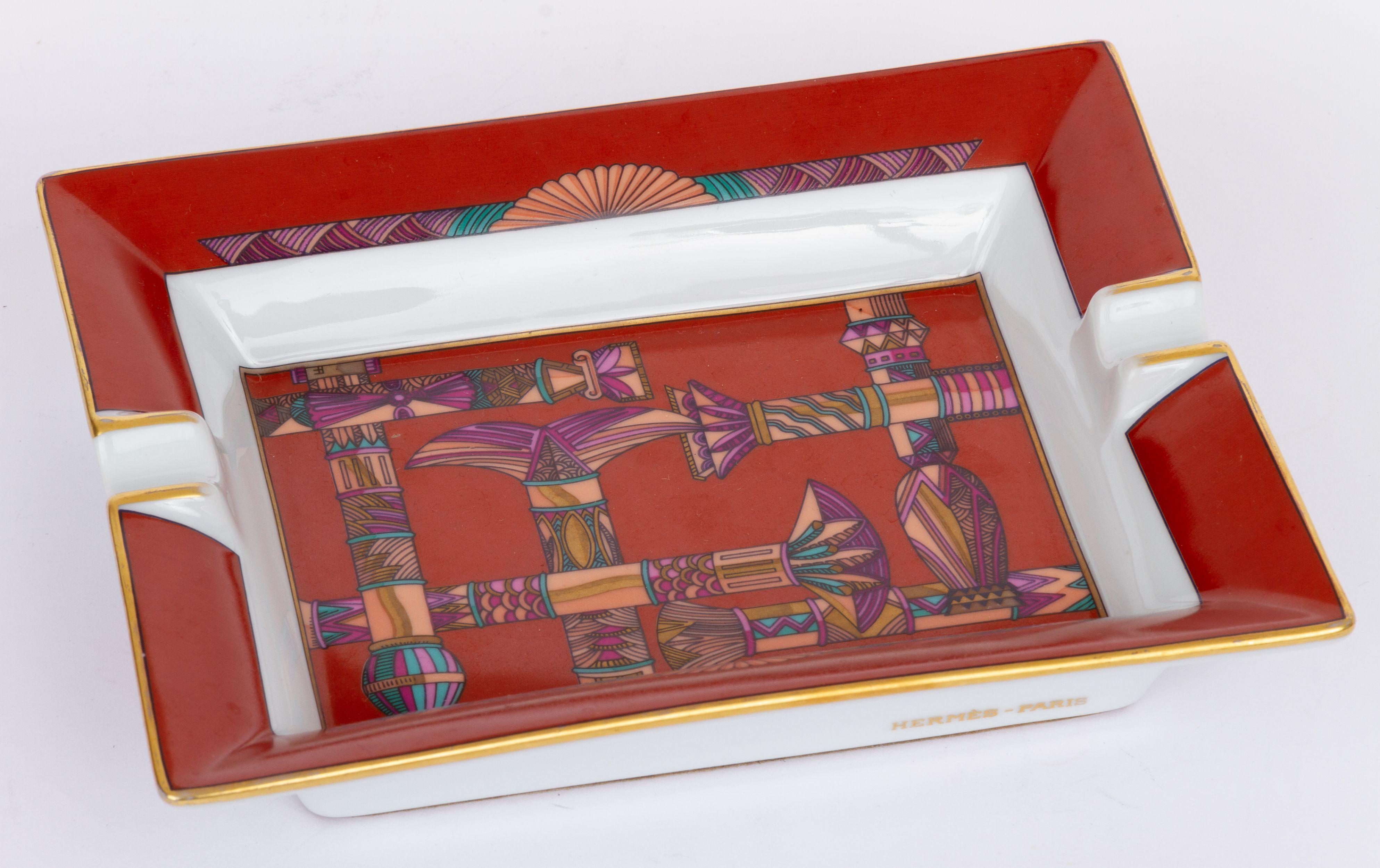 Hermès vintage ashtray in the main color red. The center of the piece shows a print of different columns. It is in excellent condition.