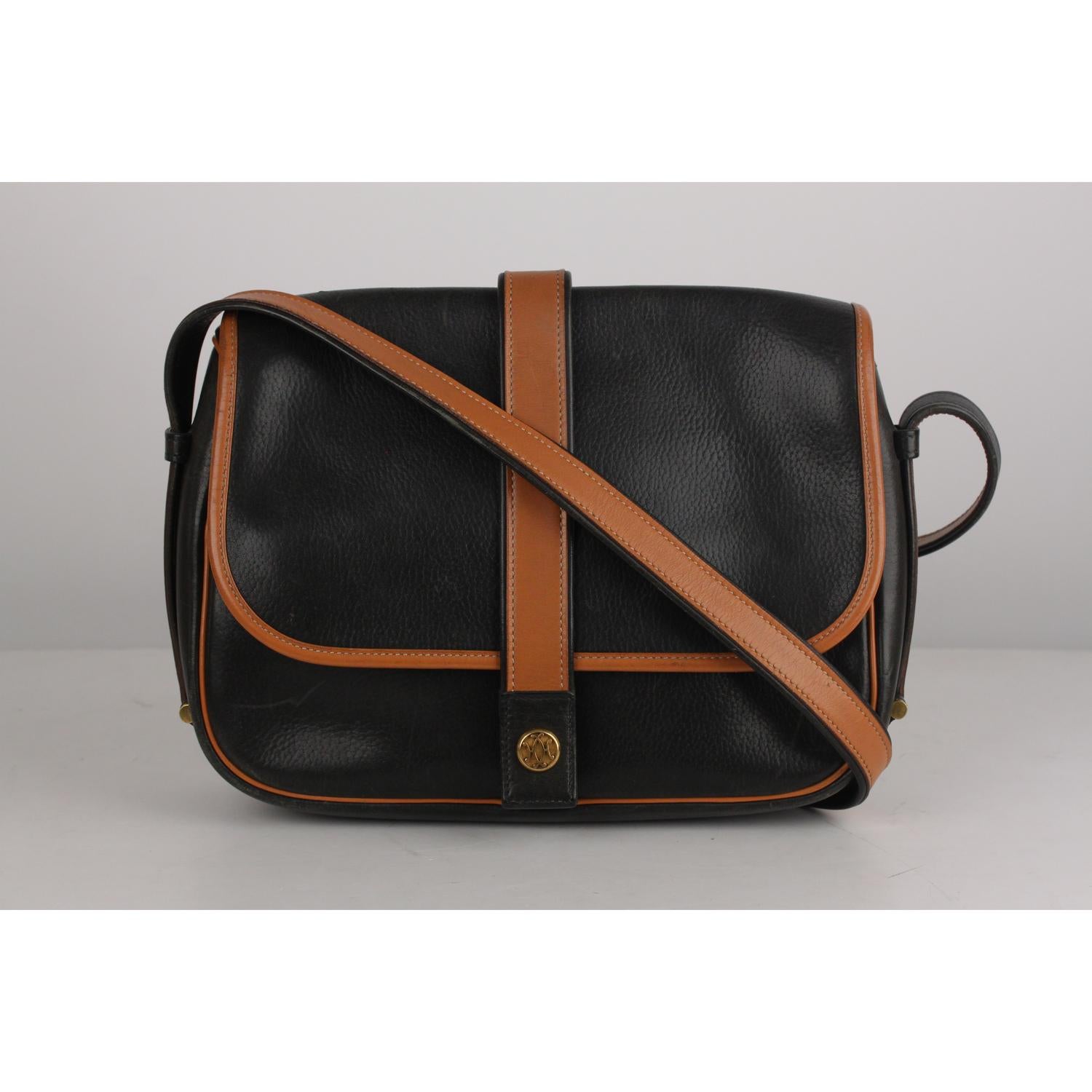 Vintage Hermes 'Noumea'  Messenger bag with bicolor design. Black and genuine leather. The bag features a leather shoulder strap, Flap with a fold-over strap and button closure, and open pocket under the flap, a rear zip pocket, and beige fabric