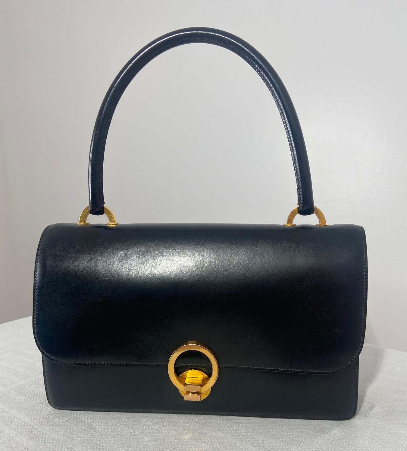 Hermès Vintage schwarzer Box Kalbsleder, vergoldet Ring Tasche, aus den 1950er Jahren. Schöne klassische Tasche mit Klappe und vergoldetem Ringverschluss. Strukturierte Tasche mit Akkordeonfalten an den Seiten, die mehr Platz im Inneren bieten. Der