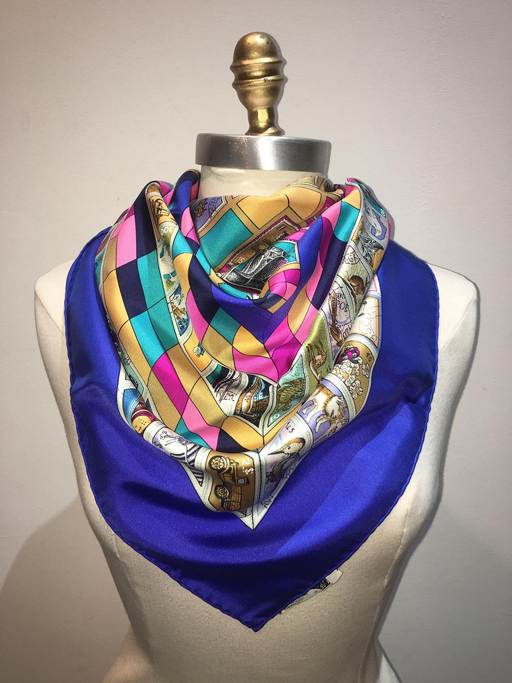 Hermes Vintage Blue Correspondence Silk Scarf c1990 in excellent condition. Original silk screen design by Cathy Latham c1990 features various multicolor stamp print and color block pattern surrounded by a blue border. 100% silk, hand rolled hem,