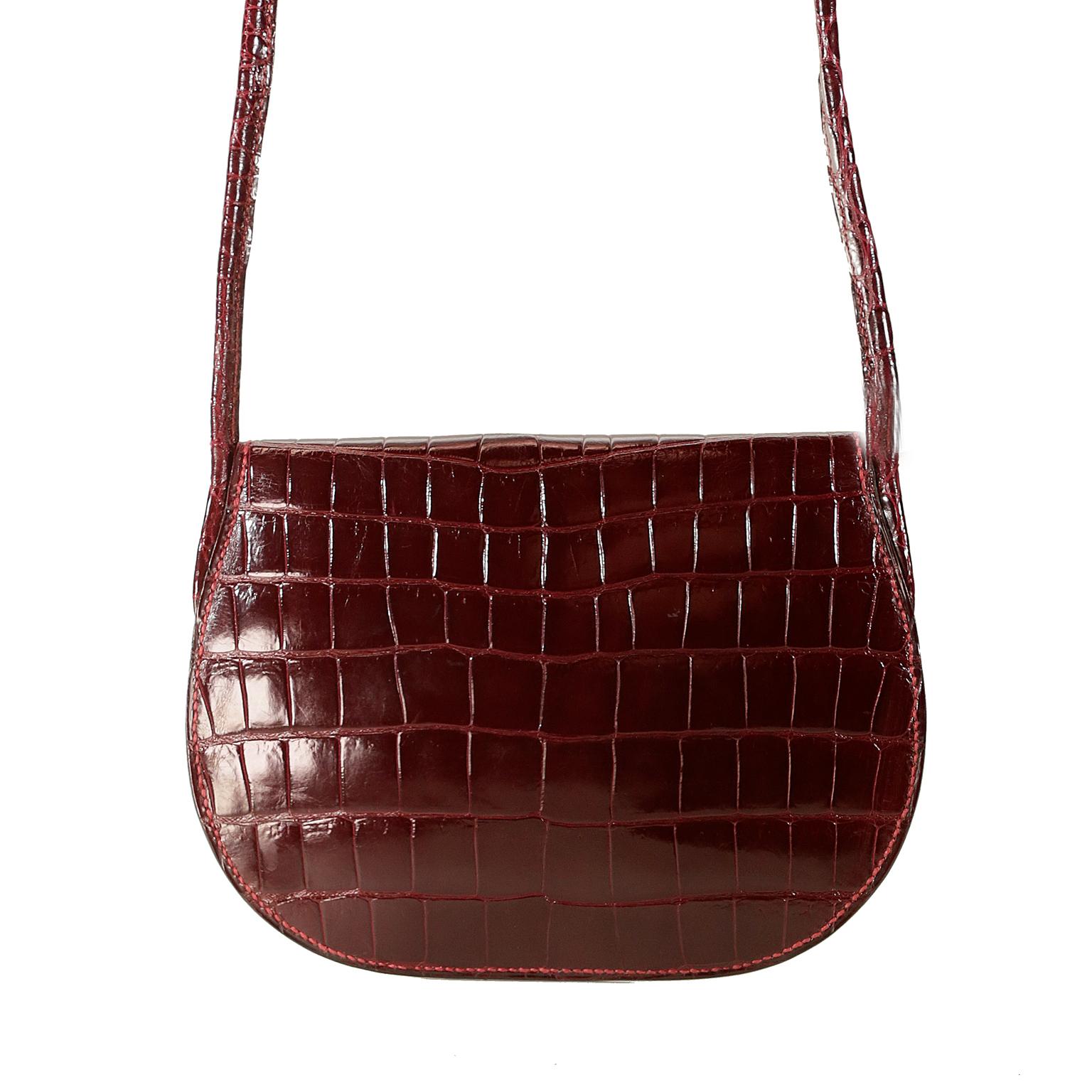 This authentic Hermès Vintage Bordeaux Crocodile Small Crossbody Bag is in excellent condition. 
Extremely rare custom ordered piece from 2000-2001.  Slim flap bag in rich Bordeaux crocodile skin with press snap closure.  Intricate equestrian