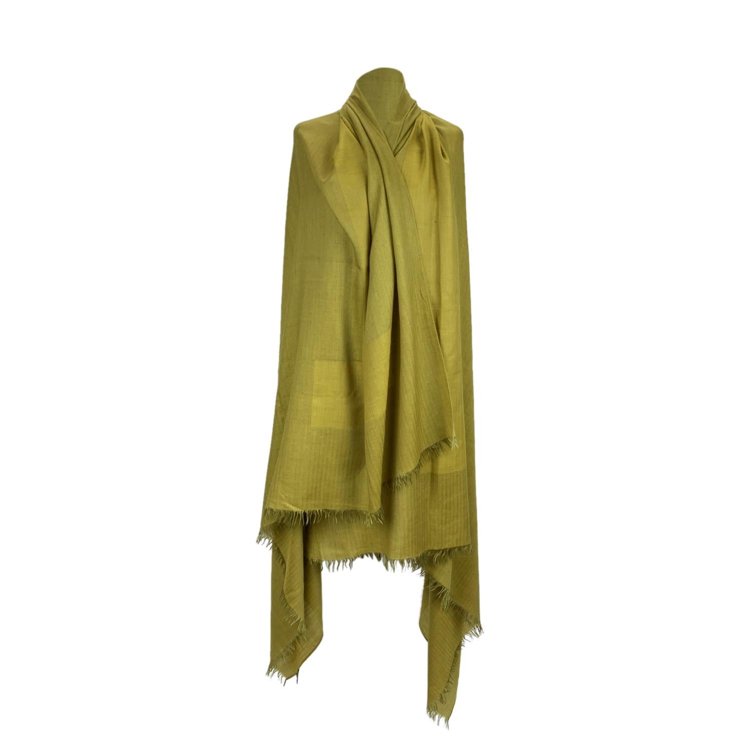 Rare cashmere, wool and silk scarf by Hermes. Green yellow color. Big H pattern in the center. Composition; 77% Cashmere, 14% New Wool, 9% Silk. Fringed hem. Approx. measurements: 60 x 80 inches - 152 x 203. Made in Italy. 'HERMES - Paris' and