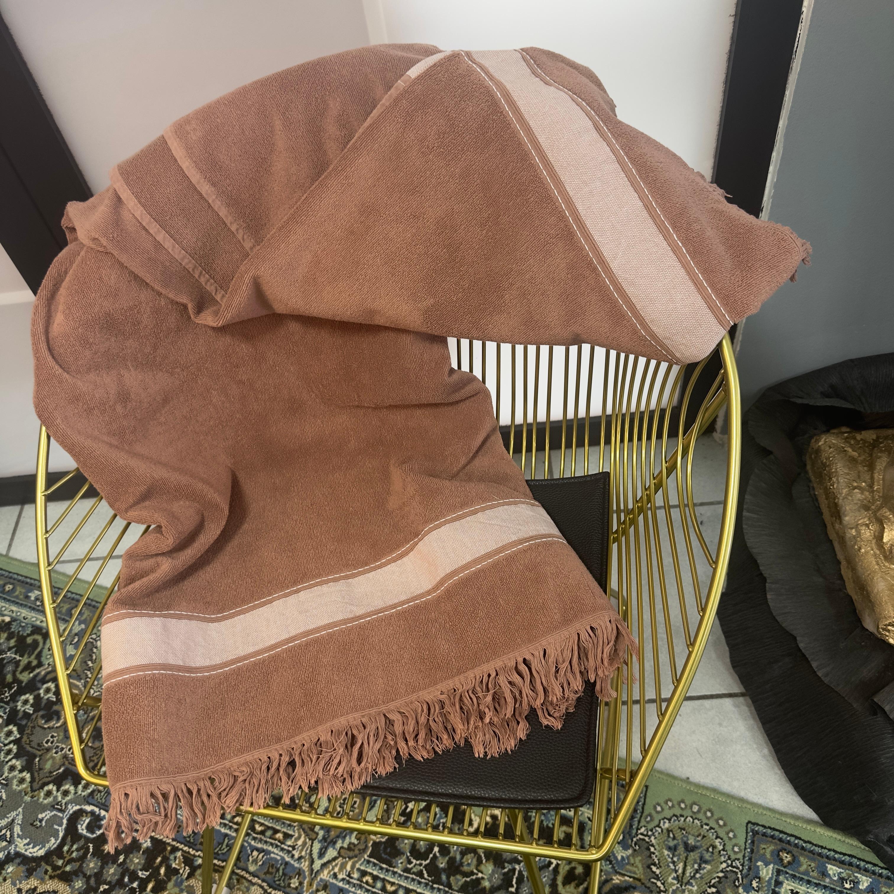 Pièce rare et très élégante d'Hermès, cette serviette vintage de couleur chocolat est un exemple de luxe discret. Réalisé en tissu éponge doux et de qualité, il présente des franges sur les deux petits côtés et une bande de tissu ton sur ton avec la