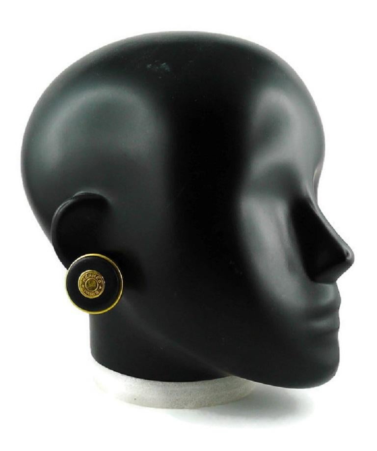 HERMES vintage gold toned and black leather Clou de Selle clip-on earrings. 

Embossed HERMES PARIS.

Indicative measurements : diameter approx. 3 cm (1.18 inches).

JEWELRY CONDITION CHART
- New or never worn : item is in pristine condition with no