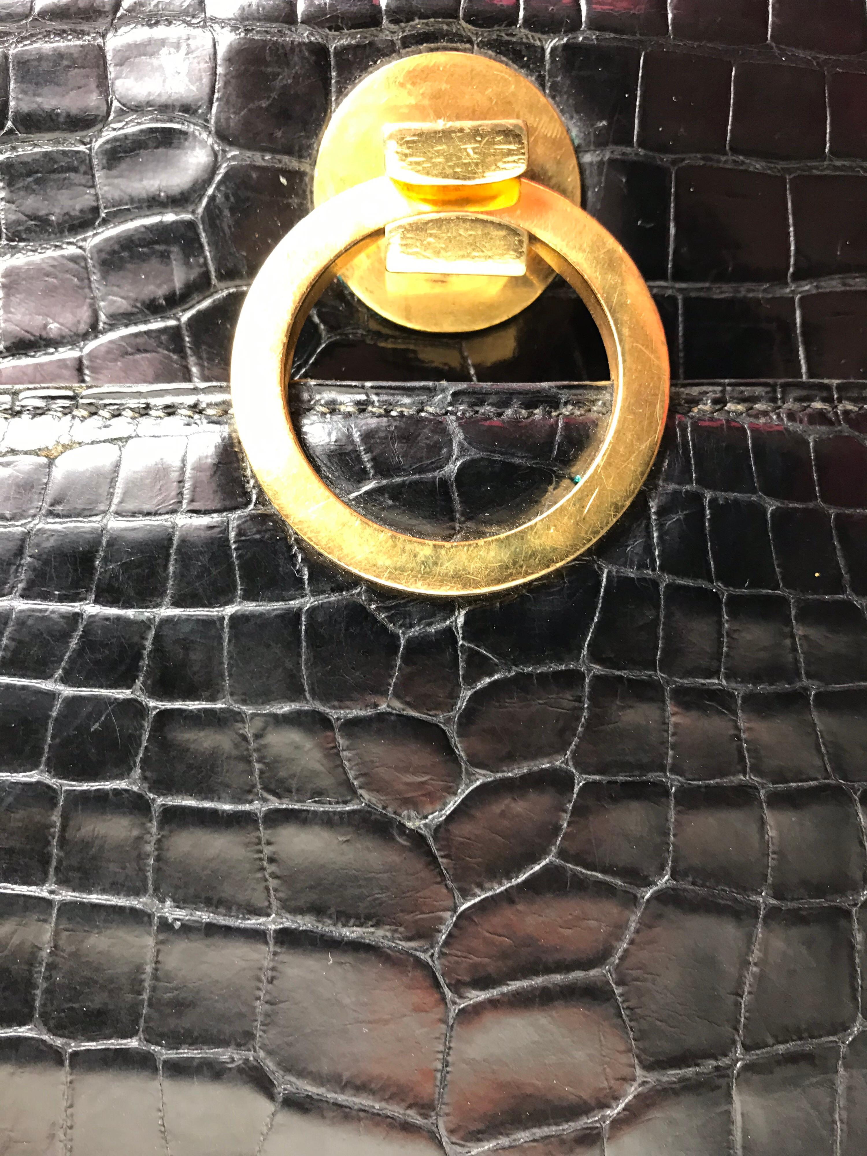 Hermès black crocodile vintage Sac Ring bag with gold-tone hardware. Single pocket at front flap underside, dual interior compartments, four pockets. 7” height, 10.25” width, 1.5” depth. Condition good wear to exterior and interior 